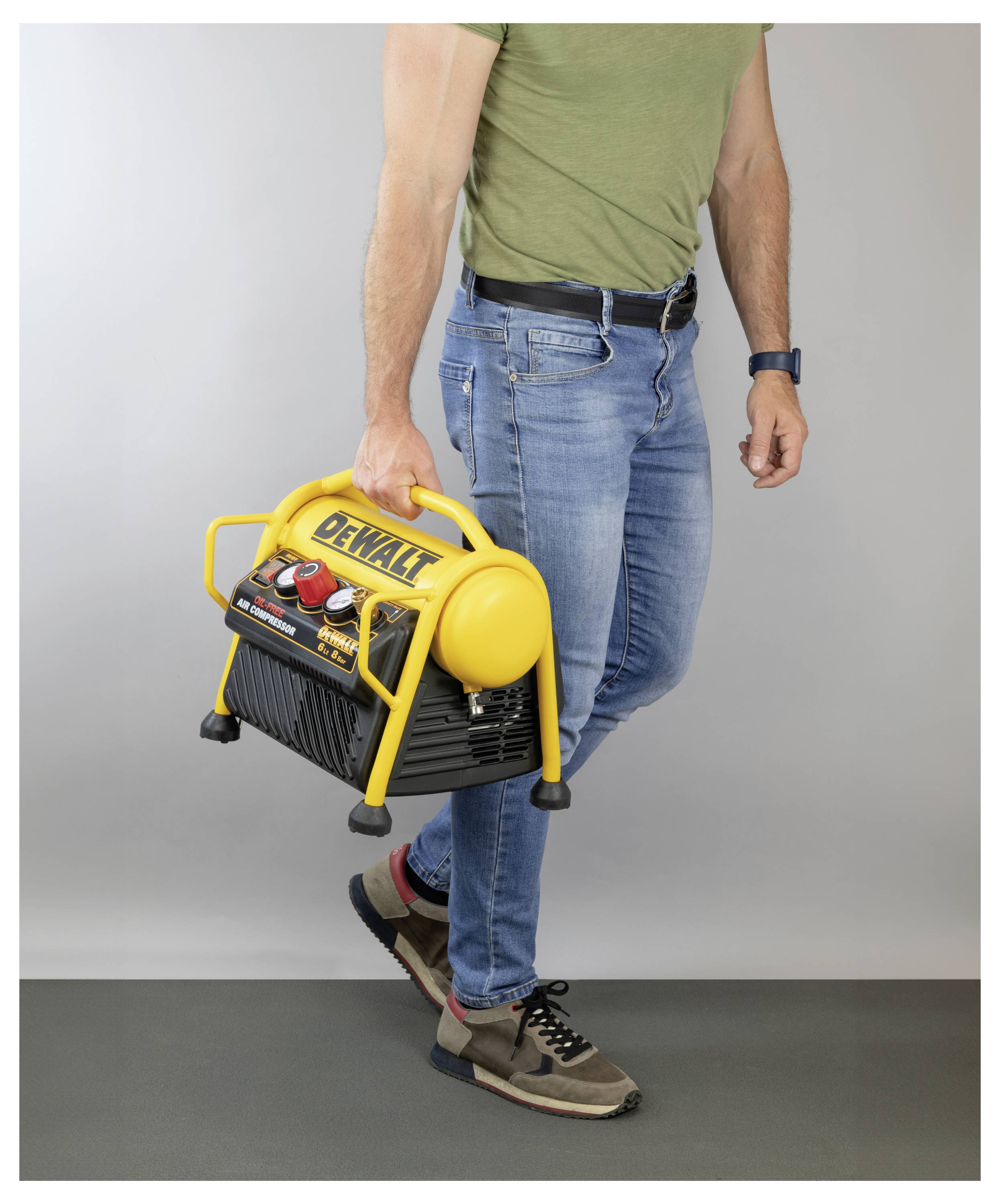 Een persoon draagt een compacte, gele luchtcompressor met het merk 'DeWalt' tegen een neutrale achtergrond, wat het draagbare ontwerp ervan toont.