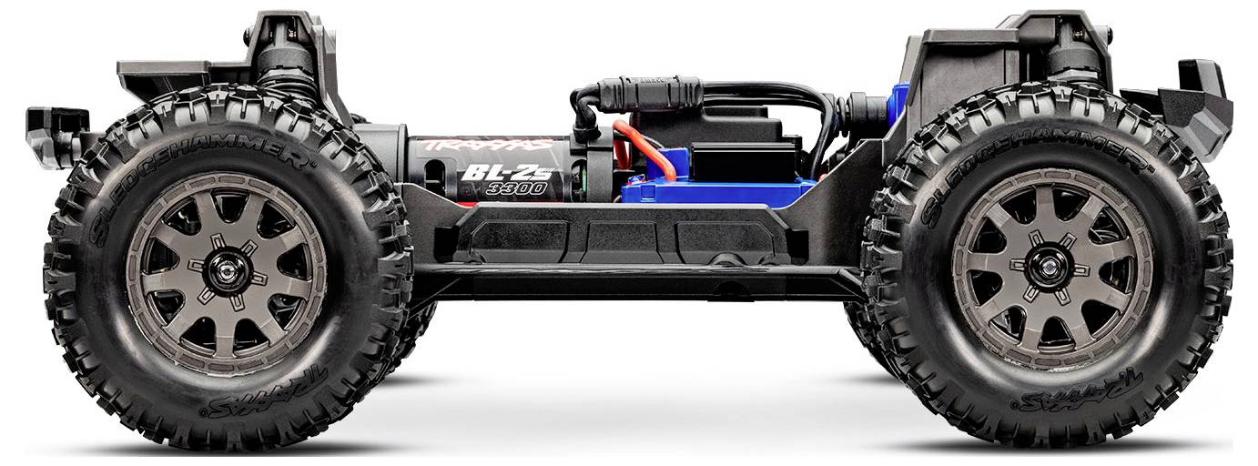 De afbeelding toont een blootgesteld frame van een RC-auto met grote terreinbanden, waarbij de interne componenten zoals de motor en ophanging zichtbaar zijn.