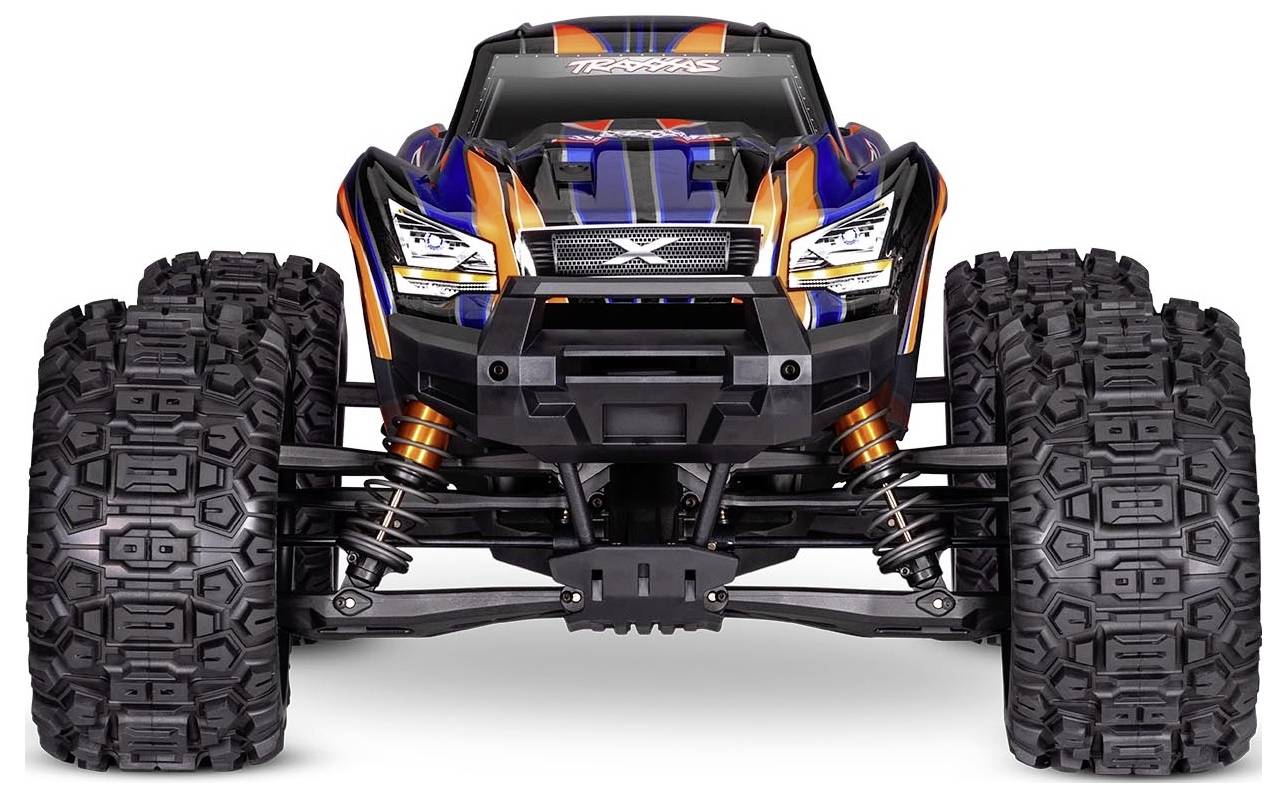 Een afstandsbediende monstertruck met grote gestructureerde banden, en een levendig oranje en blauw carrosserie, bekeken van voren.