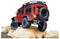 Een rode off-road RC-voertuig klimt over grote rotsen, waarbij zijn robuuste ontwerp en grote banden worden getoond. De focus benadrukt zijn terreinvaardigheden.