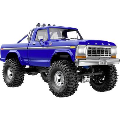 Een blauwe, vintage Ford truck met grote terreinbanden en een rolbeugel wordt getoond onder een hoek, waarbij zijn robuuste ontwerp wordt tentoongesteld.