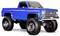Een blauwe vintage verhoogde pick-uptruck met grote terreinbanden en chromen details, die een robuust en klassiek design tentoonspreiden.