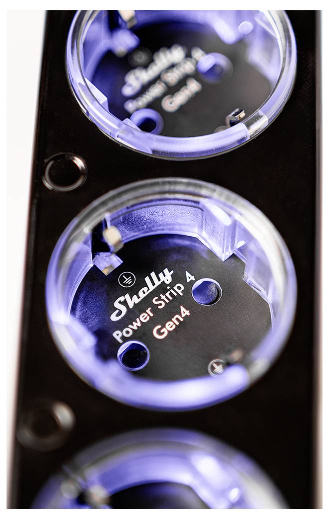 Een zwarte stekkerdoos met drie ronde stopcontacten, elk gelabeld als 'Shelly Power Strip 4 Gen4', verlicht met blauw licht.