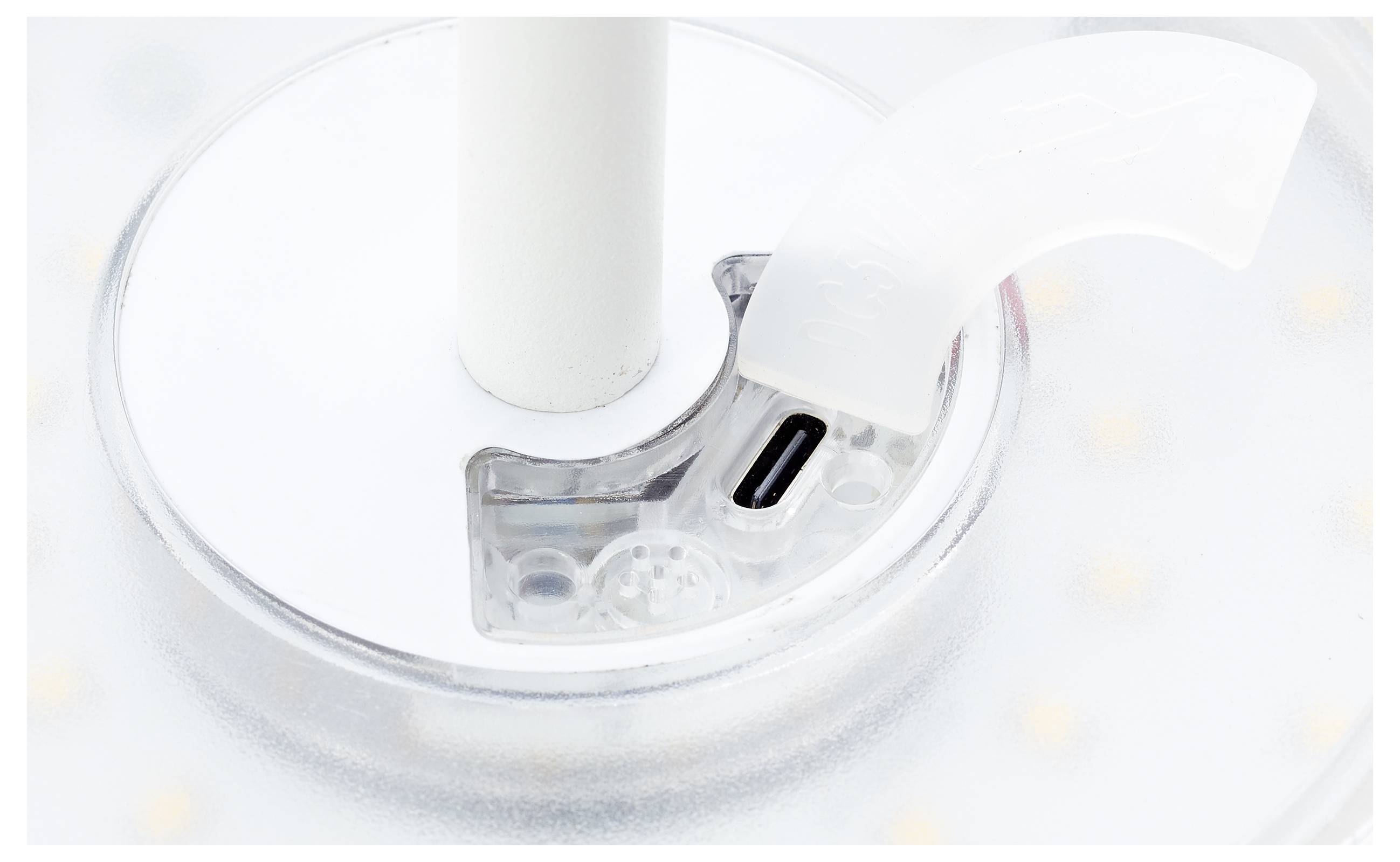 Een circulaire LED-lichtcomponent met een USB-C-poort, omgeven door een doorschijnende kunststof behuizing, is gemonteerd op een witte standaard.