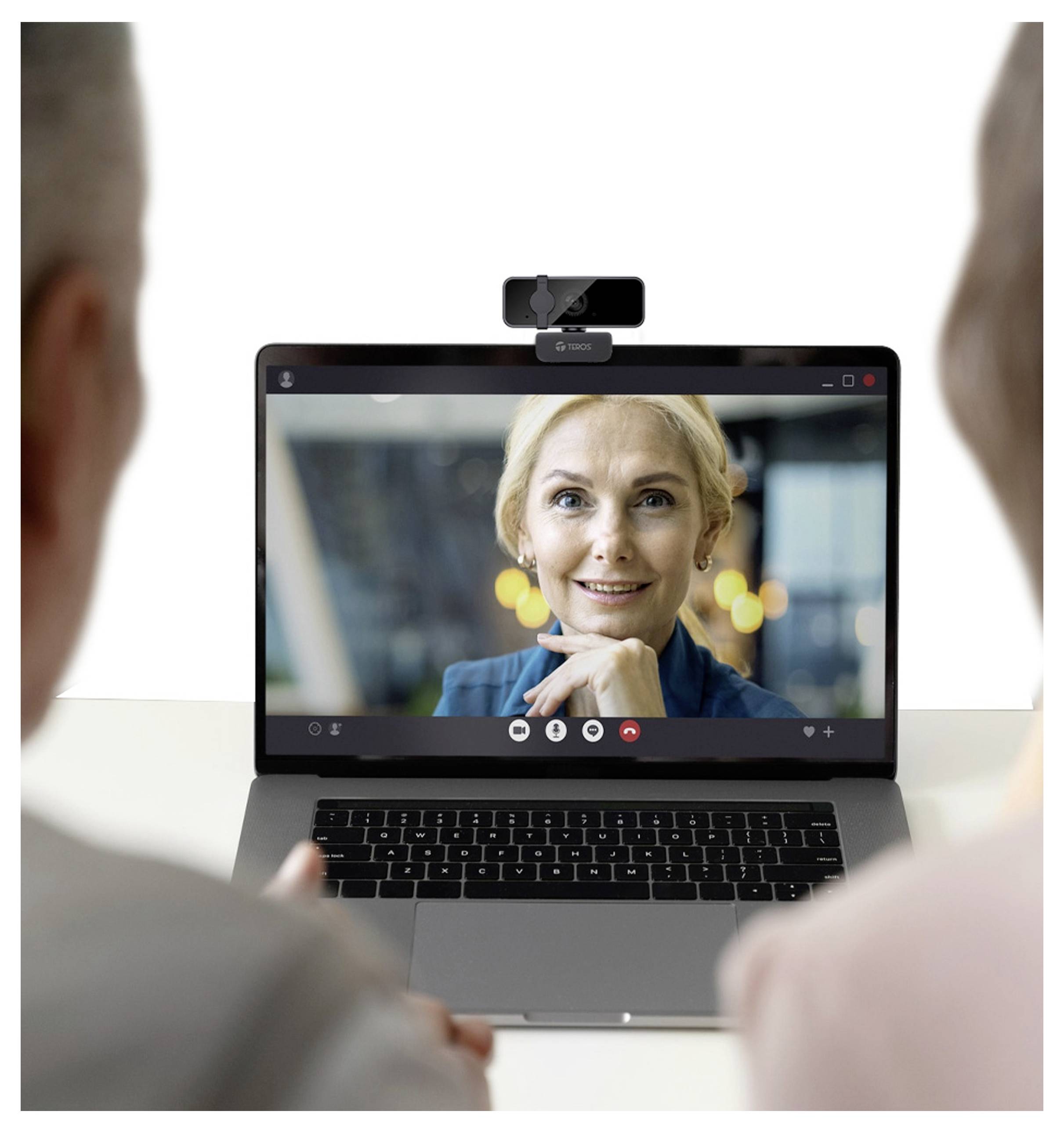 Twee mensen nemen deel aan een videogesprek op een laptop. Een vrouw op het scherm spreekt, en er is een webcam aan de laptop bevestigd.