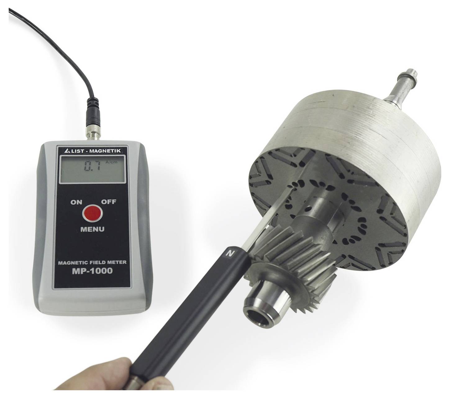 Draagbare magnetische veldmeter die 0,1 aangeeft naast een metalen rotor of motoronderdeel dat wordt getest met een probe.
