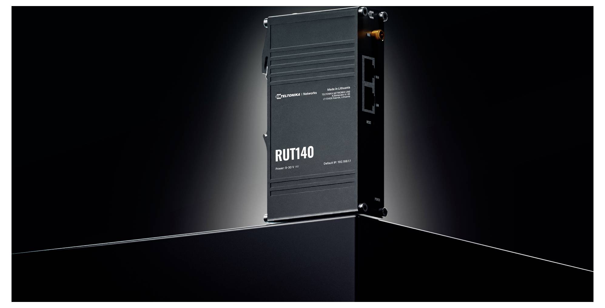Een zwarte industriële router 'RUT140' op een slanke, hellend oppervlak met zichtbare Ethernet-poorten, tegen een donkere achtergrond.
