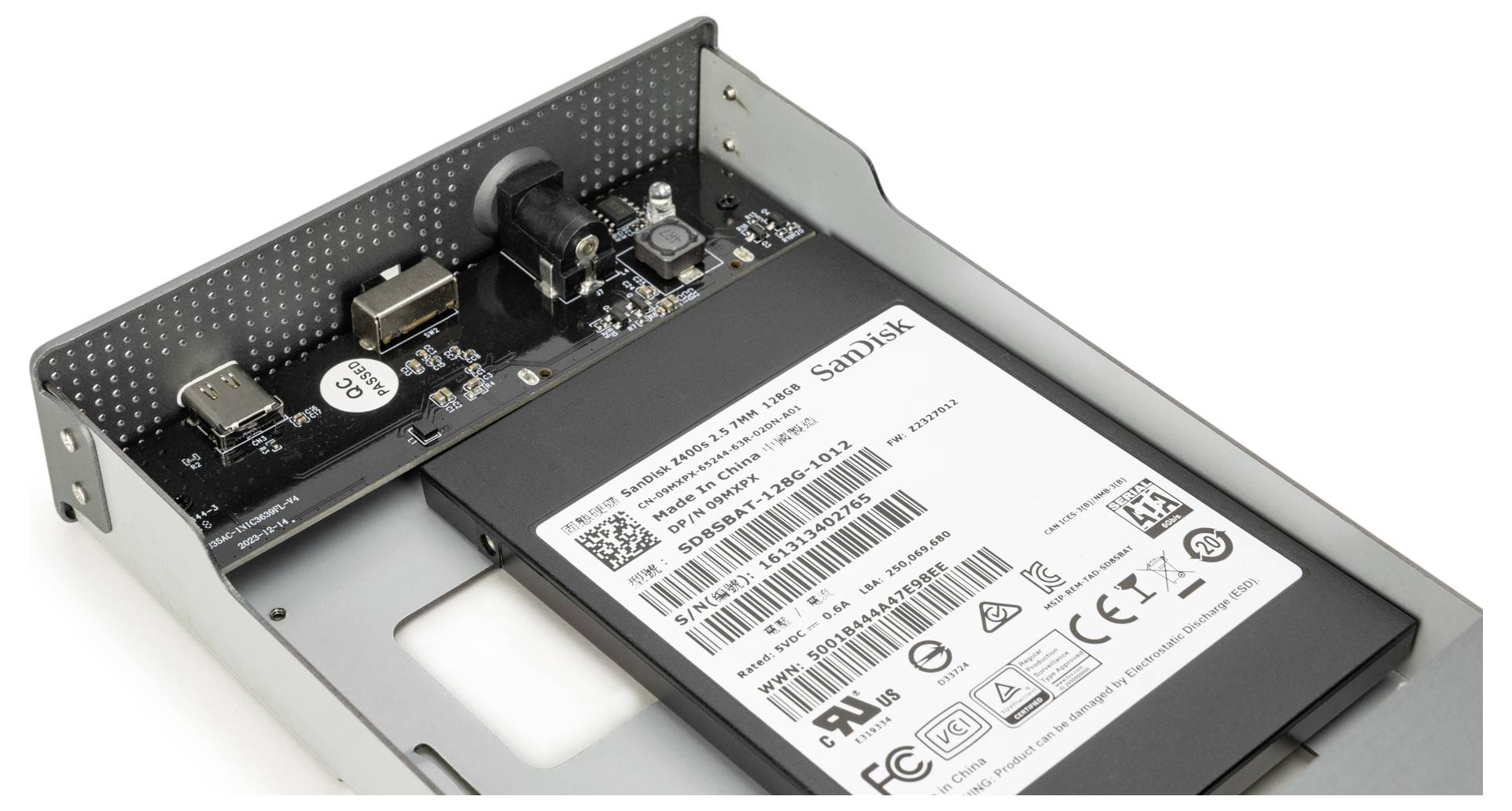 'Open harde schijf behuizing met zichtbare printplaat en een gemonteerde SanDisk SSD, voorzien van verschillende poorten en connectoren.'