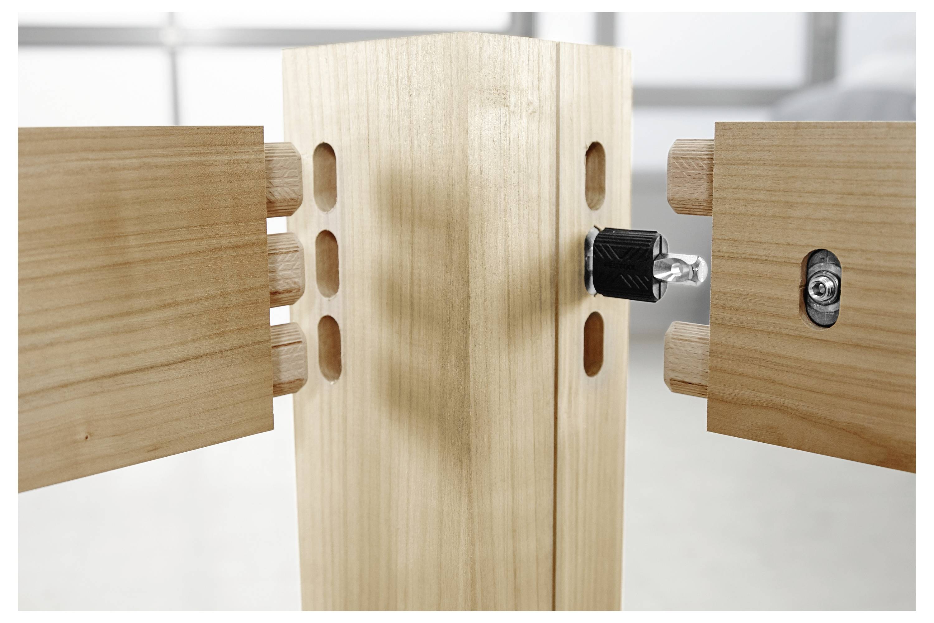 Een houten meubelstuk wordt in elkaar gezet, met twee zijpanelen met doelen die zijn uitgelijnd om aan te sluiten op de centrale paal.