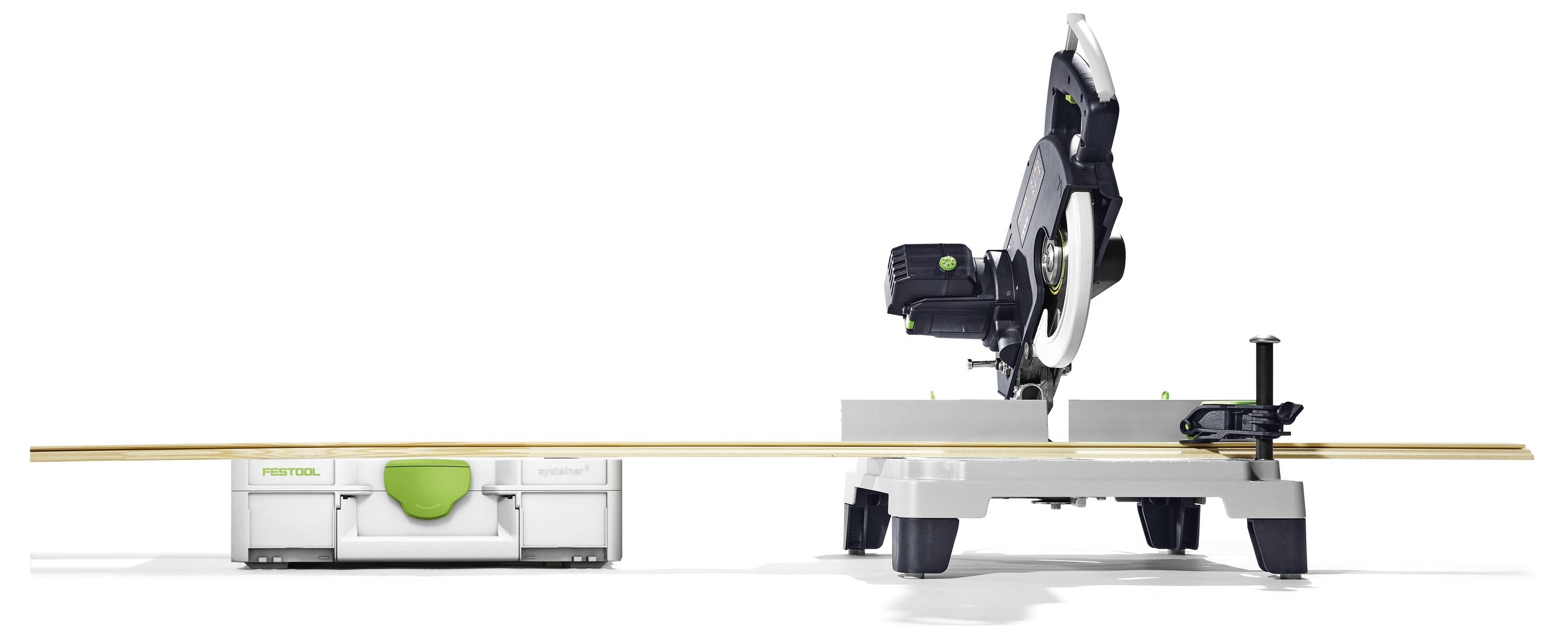 Een verstekzaag op een standaard, naar links gekanteld, met een lang stuk hout. Een Festool-koffer is dichtbij, wat ook het merk aanduidt.