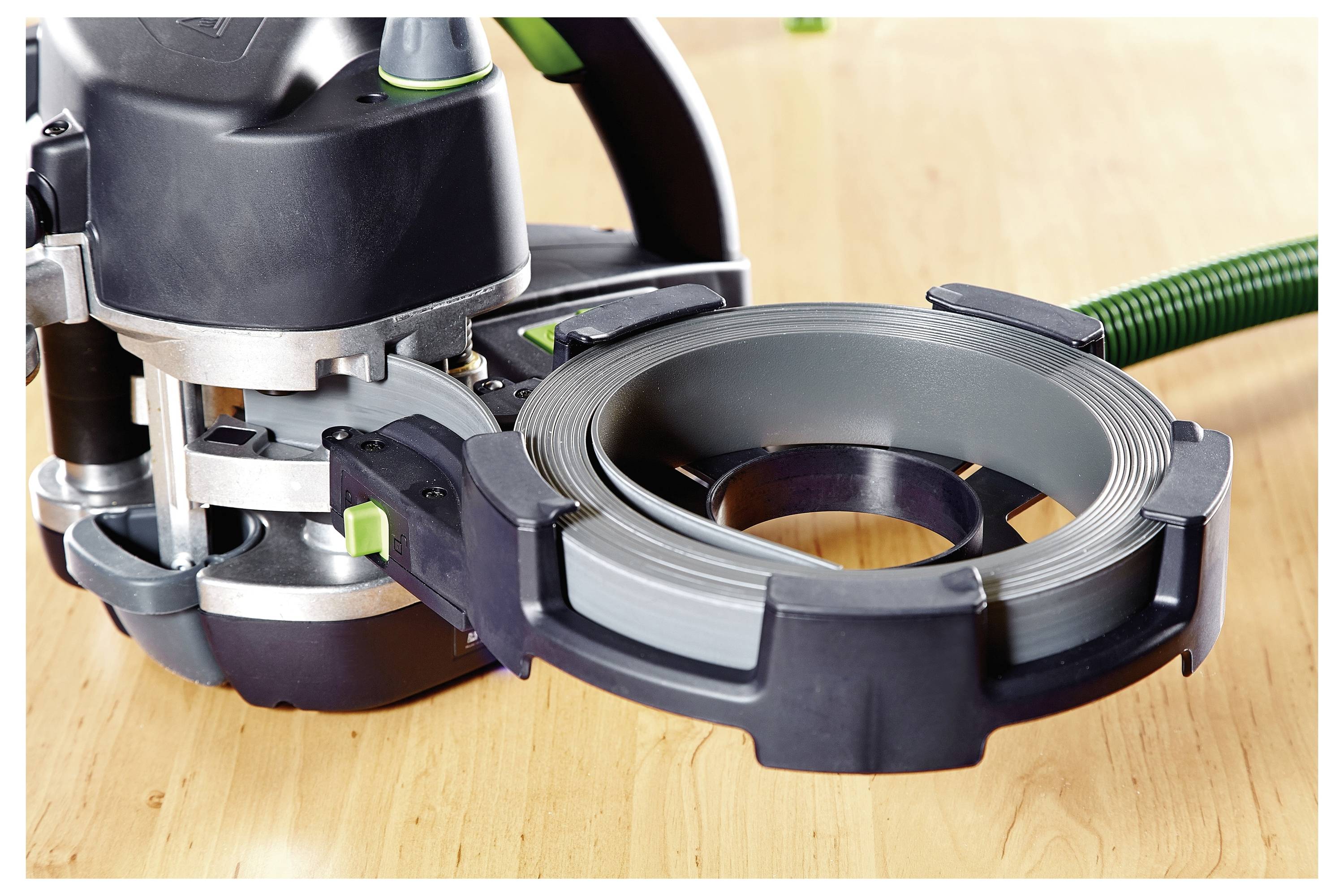 Een zwart en groen randafwerkingsprogramma geplaatst op een houten oppervlak, gebruikt voor het aanbrengen van randafwerking op meubelsranden.