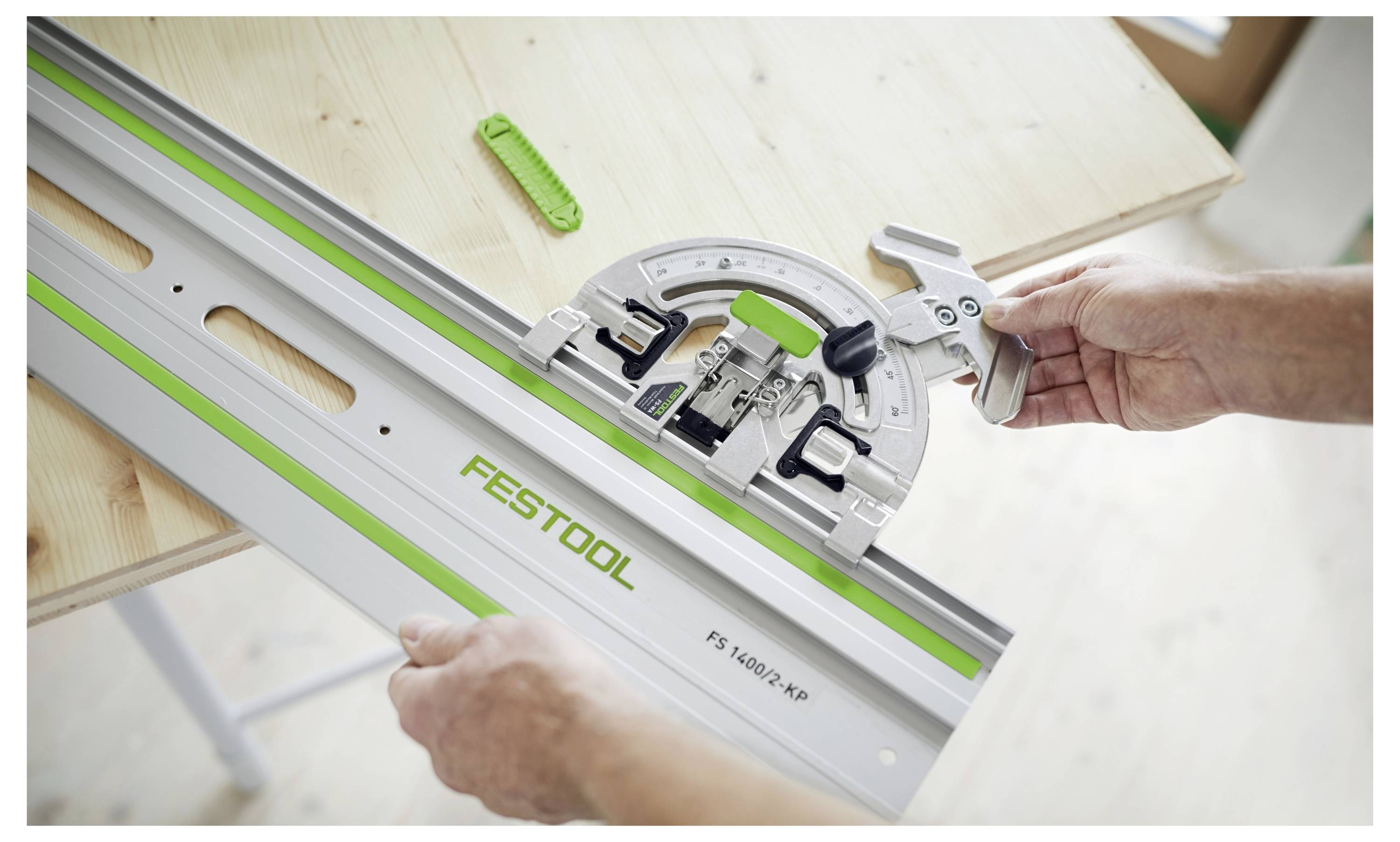 'Een persoon stelt een Festool cirkelzaaghandleiding op een houten tafel in, en demonstreert het gebruik ervan voor nauwkeurig hoekzagen.'
