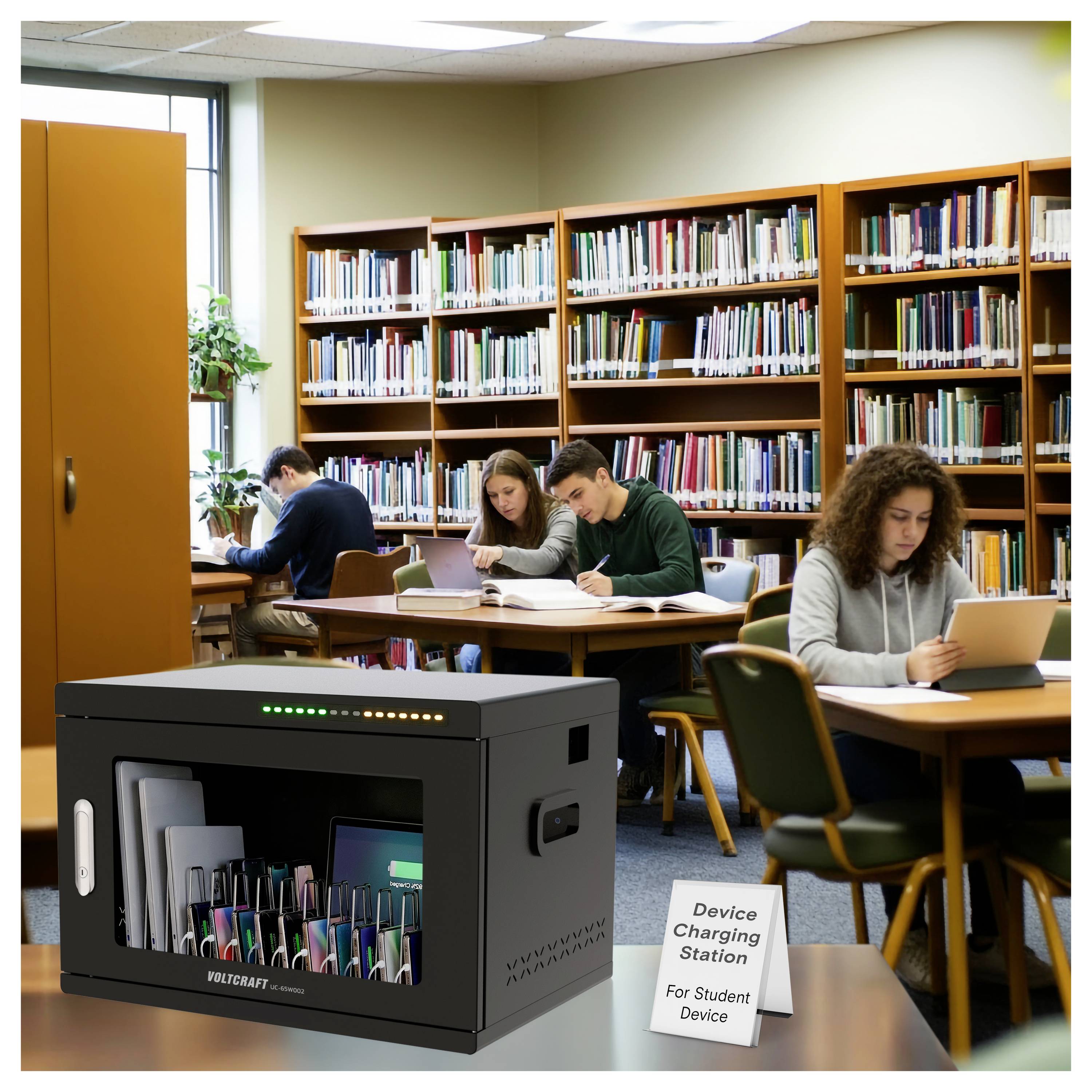 Bibliotheekstudeerruimte met studenten die aan tafels lezen, en een oplaadstation voor studentenapparaten op de voorgrond.