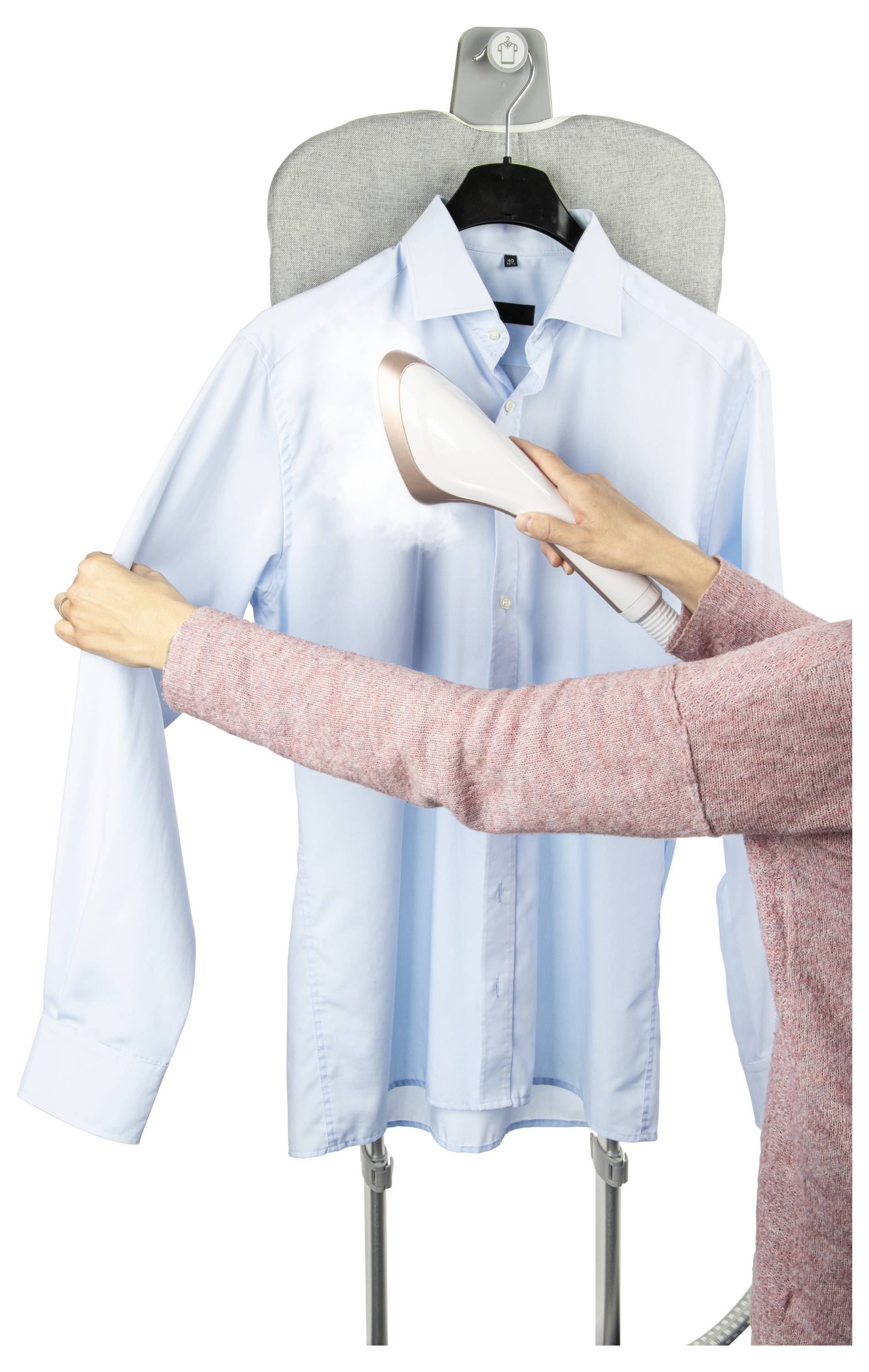 'Een persoon gebruikt een handdampstoomapparaat op een blauw shirt dat aan een strijkplank hangt, en geeft stoom af om rimpels te verwijderen.'
