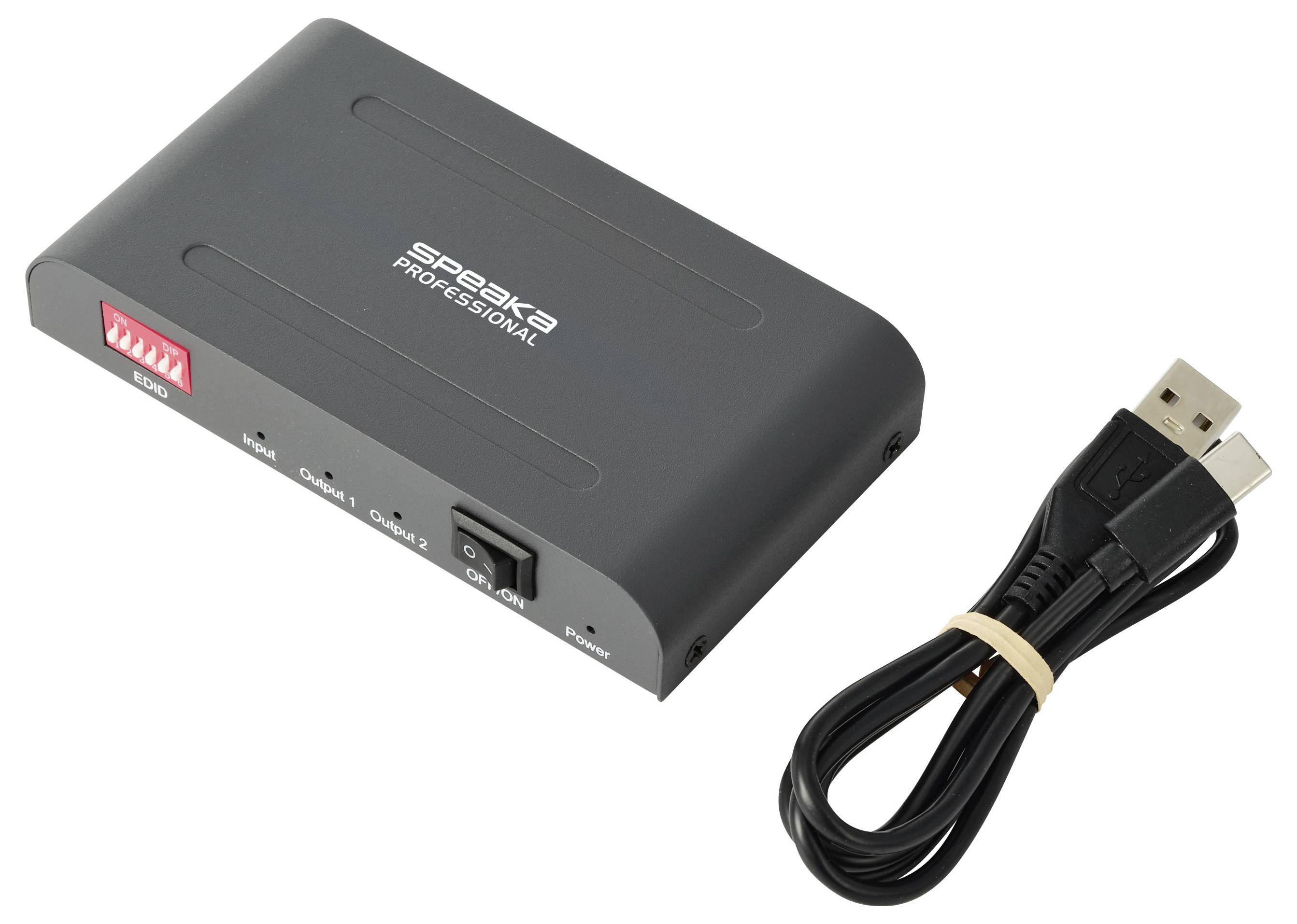 USB audio adapter box met een zwarte USB-kabel ernaast, gelabeld 'Speaka Professional' en met DIP-schakelaars en aan/uit-schakelaar zichtbaar.