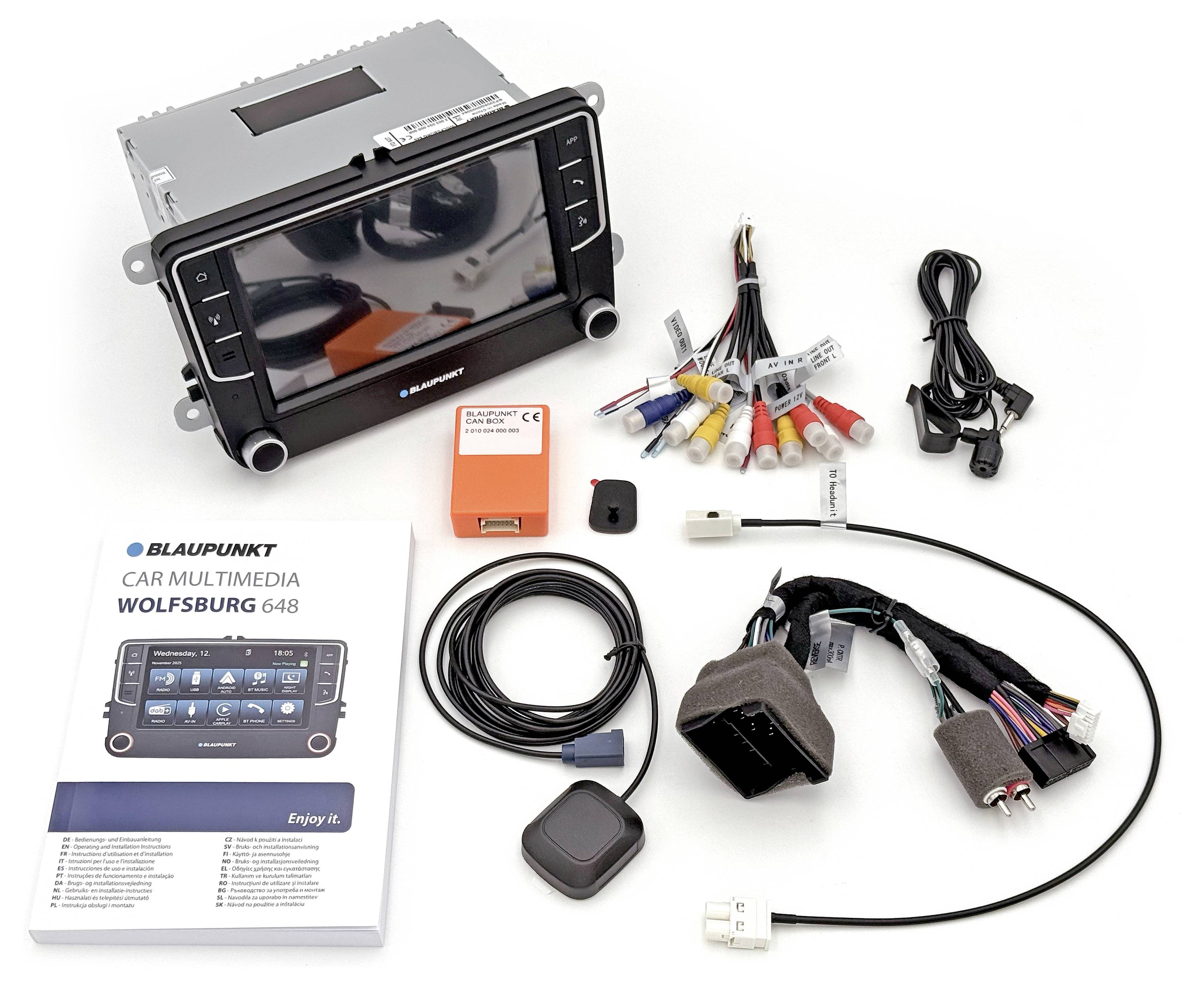 'Blaupunkt Car Multimedia Wolfsburg 648' systeem met handleiding, kabels, connectors en hardwarecomponenten weergegeven op witte achtergrond.