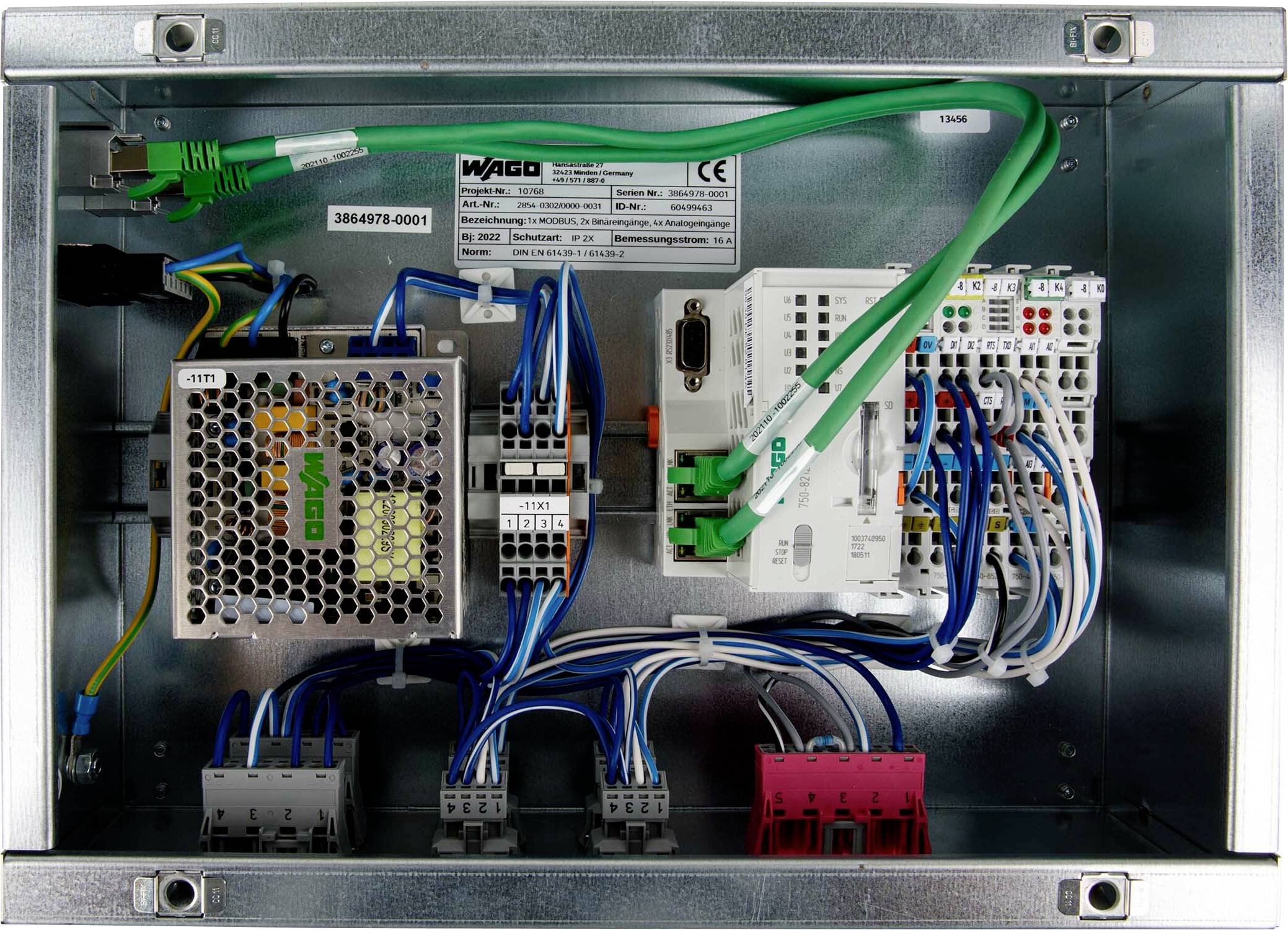 Metalen behuizing met verschillende elektronische componenten, kabels en connectoren. Bevat een WiFi-apparaat en een gedeeltelijk zichtbaar label met nummers.