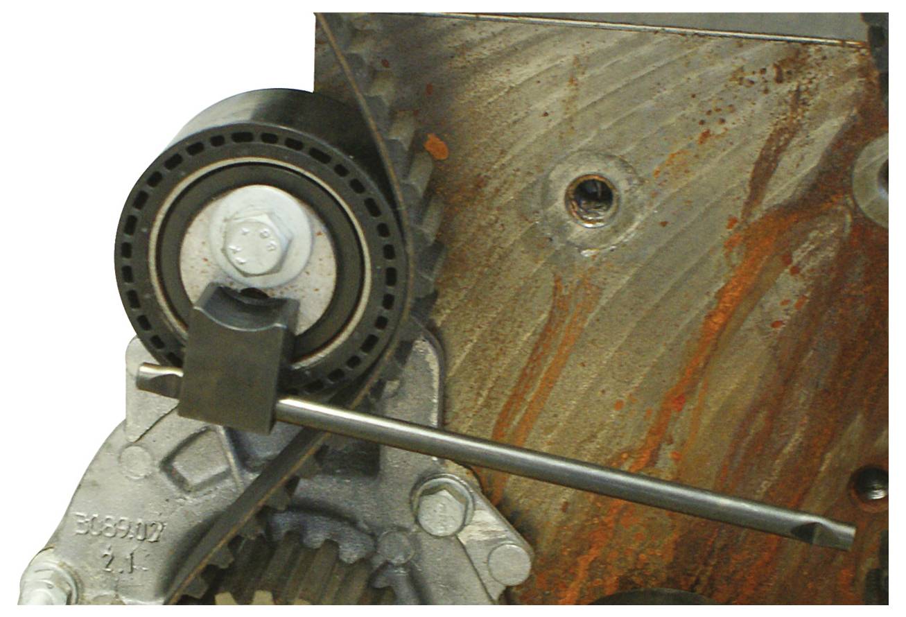 Een close-up van een machineonderdeel met een tandwiel en een geroeste metalen oppervlak, dat slijtage en beschadiging in een industriële omgeving toont.