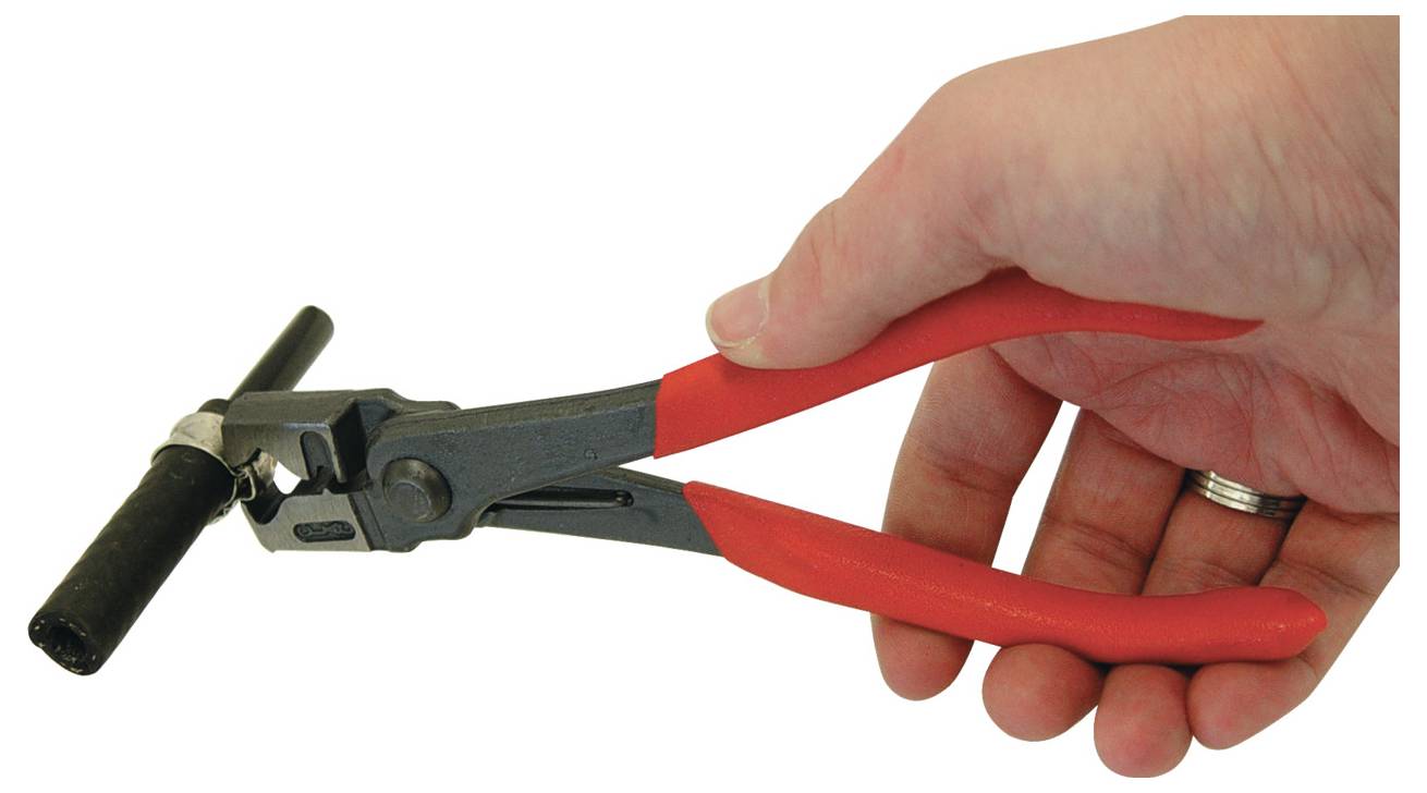 Een hand die een gereedschap met rode handvat vasthoudt, mogelijk een spangereedschap voor kabelbinders, dat een zwarte kabelbinder aanpast die rond een staaf is gewikkeld.