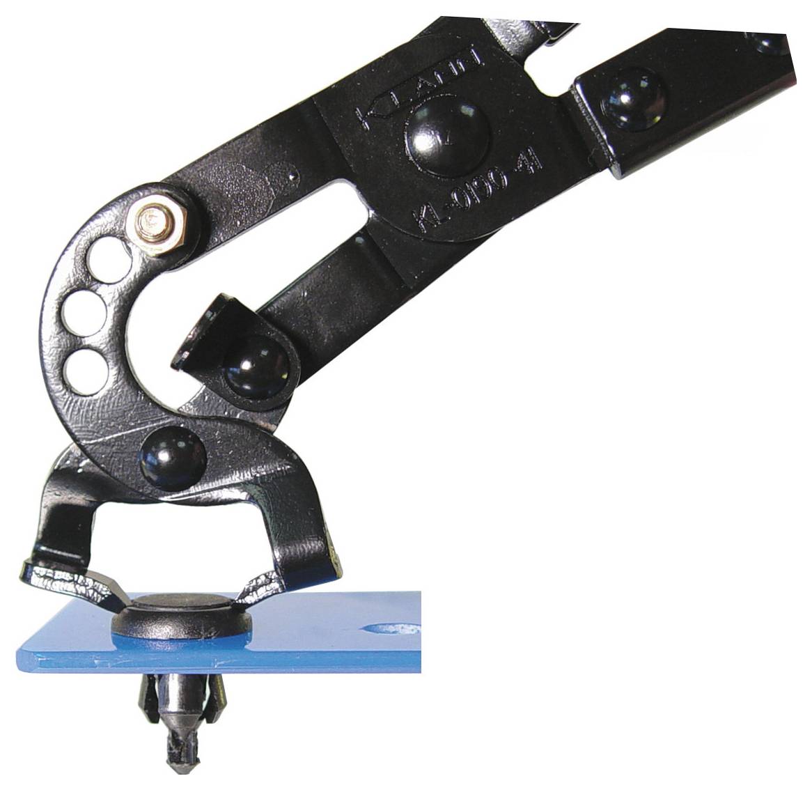 'Een metalen handgereedschap op een blauw oppervlak, gebruikt voor het maken van gaten of het aanbrengen van ogen in materialen.'