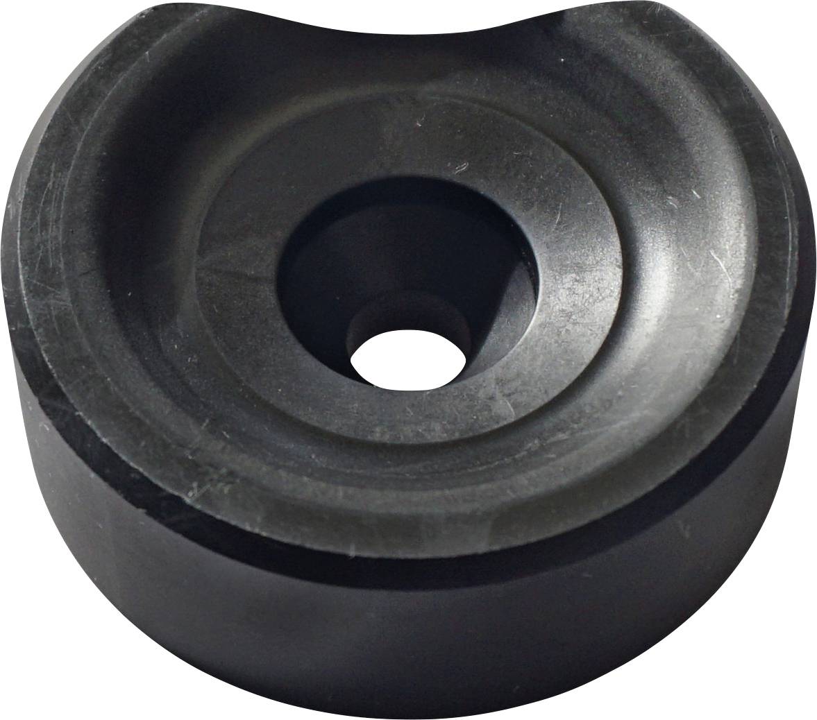 Een rond zwart rubberen object met een centraal gat, dat lijkt op een ring of plug, mogelijk gebruikt voor demping of afdichtingsdoeleinden.