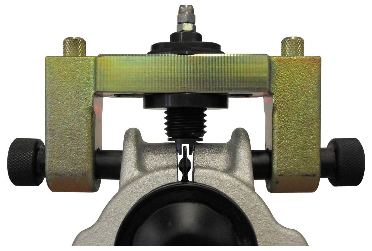 'Remklauw-zuigerterugsteltool in gebruik.'