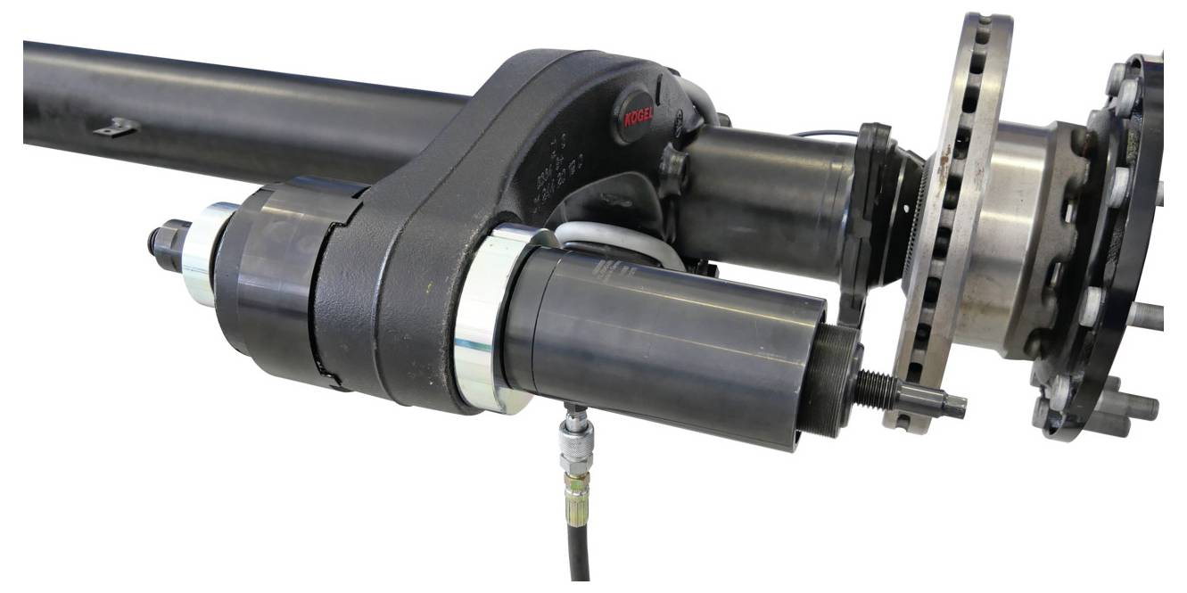 Close-up van een onderdeel van een hydraulisch aandrijfsysteem, met een cilindrische metalen motor bevestigd aan een as, met verbonden draden en bouten.