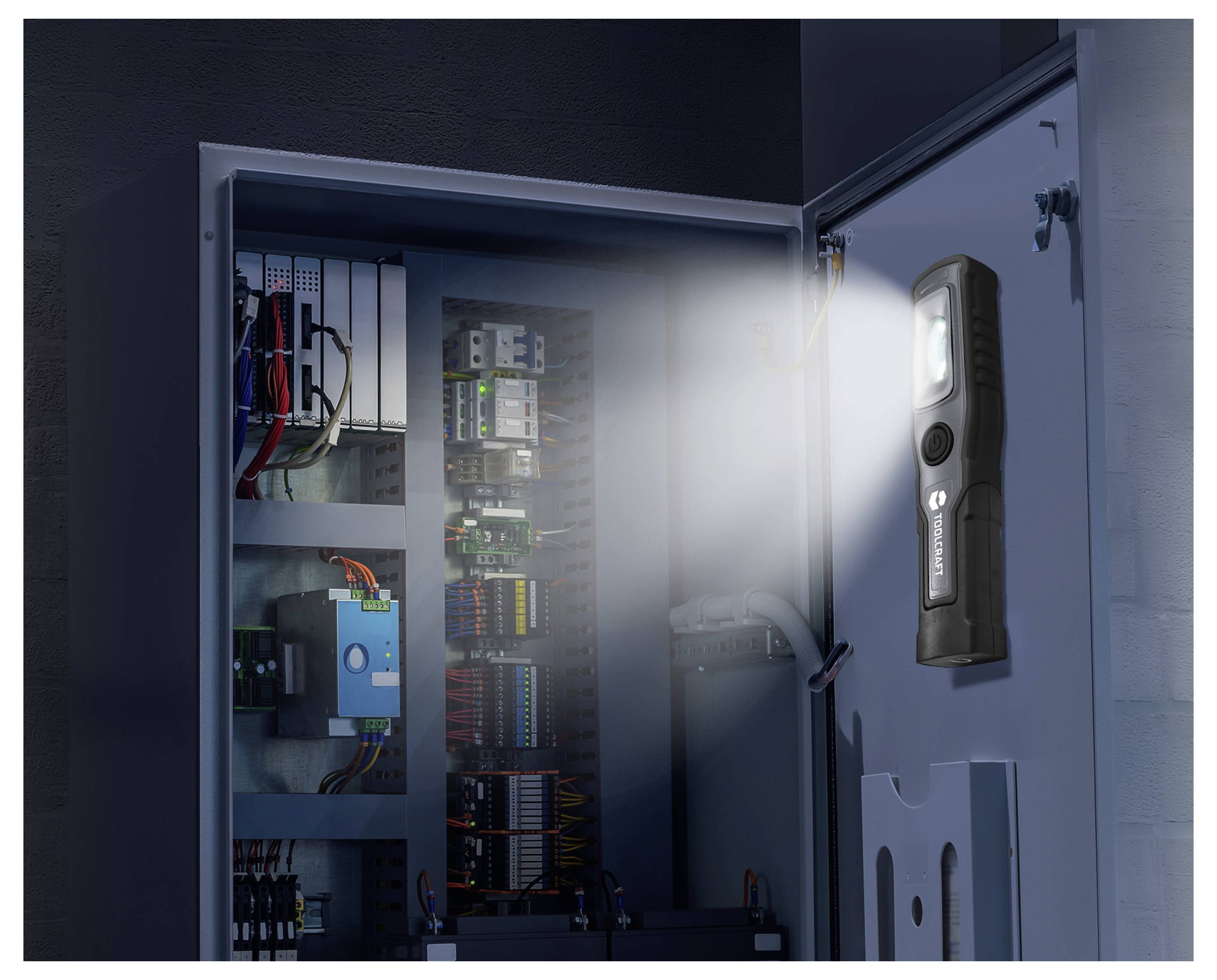 Inspectielamp gemonteerd op een open elektrisch bedieningskast, verlichtend interne bedrading en schakkelcomponenten.