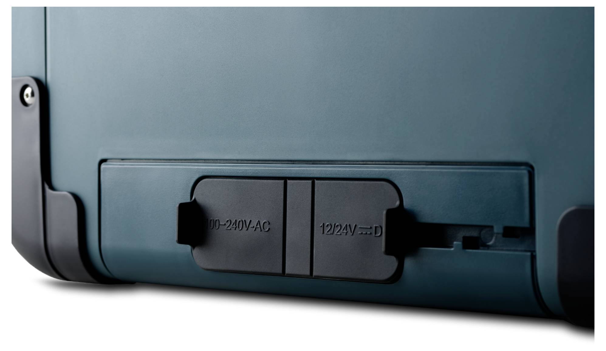 Close-up van het achterpaneel van een apparaat met een schuifbare AC-stroomingangsdeksel gelabeld '100-240V AC' en '12V/3A' ingestoken.