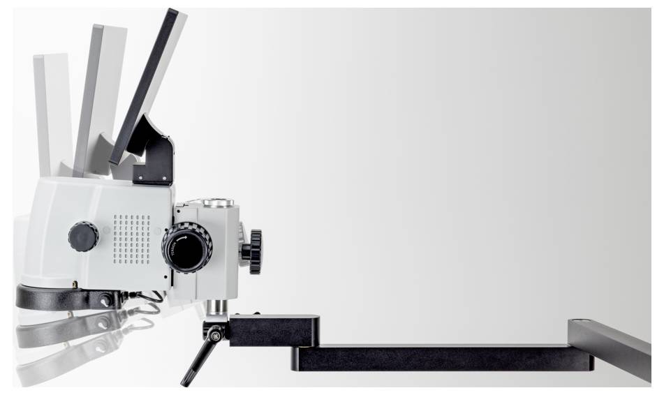 Een wit en zwart studioverlichting met verstelbare panelen is bevestigd op een metalen arm, horizontaal uitgestrekt tegen een eenvoudige achtergrond.