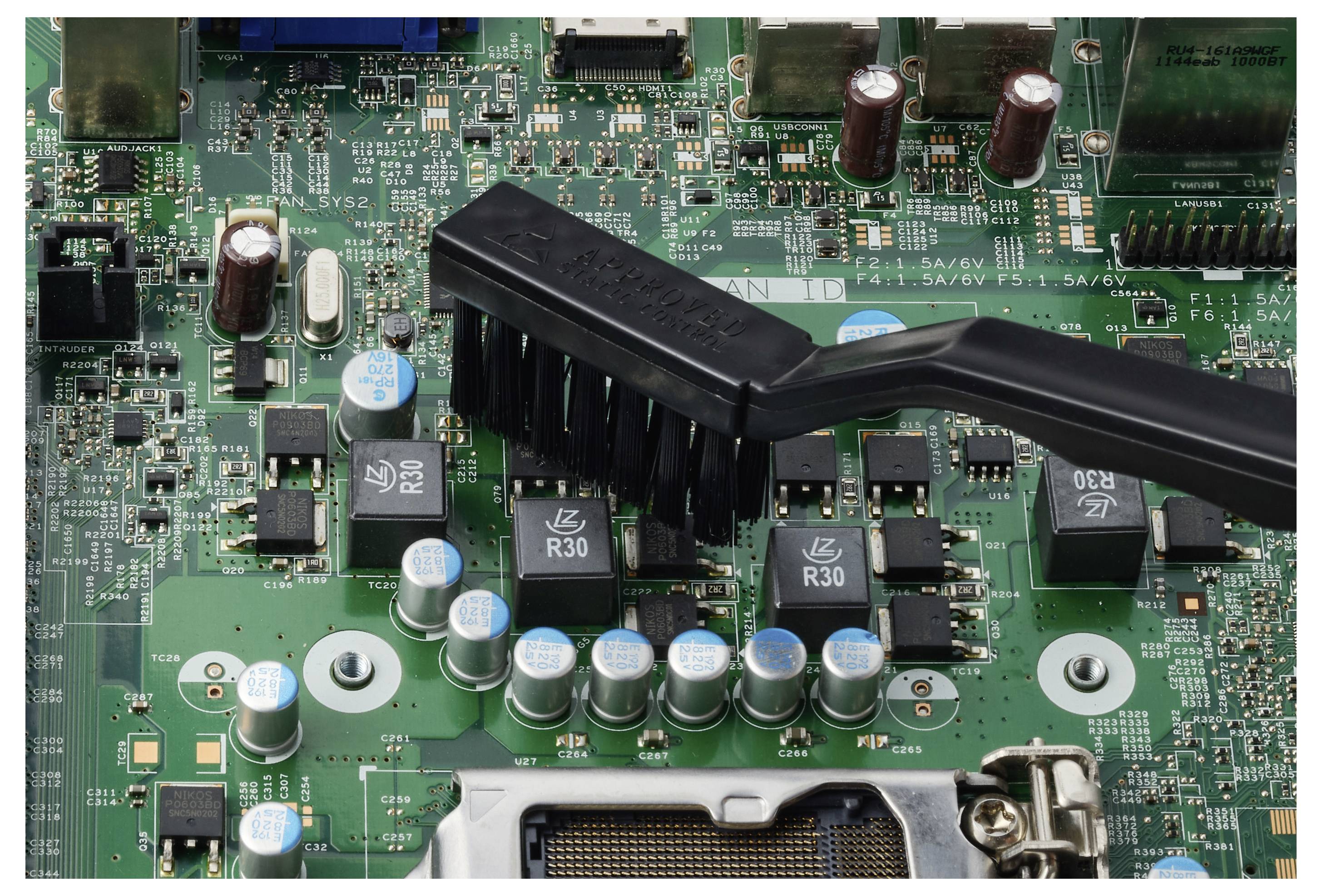 Nahaufnahme van een printplaat met zwarte kabelsamenstelling en rijen condensatoren en chips, die interne computerhard-wareverbindingen tonen.