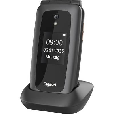 Een digitaal display toont de datum '06.01.2025' en het tijd '09:00' op een gesloten klaptelefoon die in een oplaaddock staat.