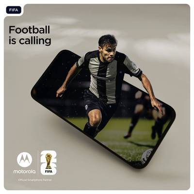 Een voetballer in een zwart-wit tenue rent over een speelveld, terwijl een smartphonescherm op de voorgrond zichtbaar is.