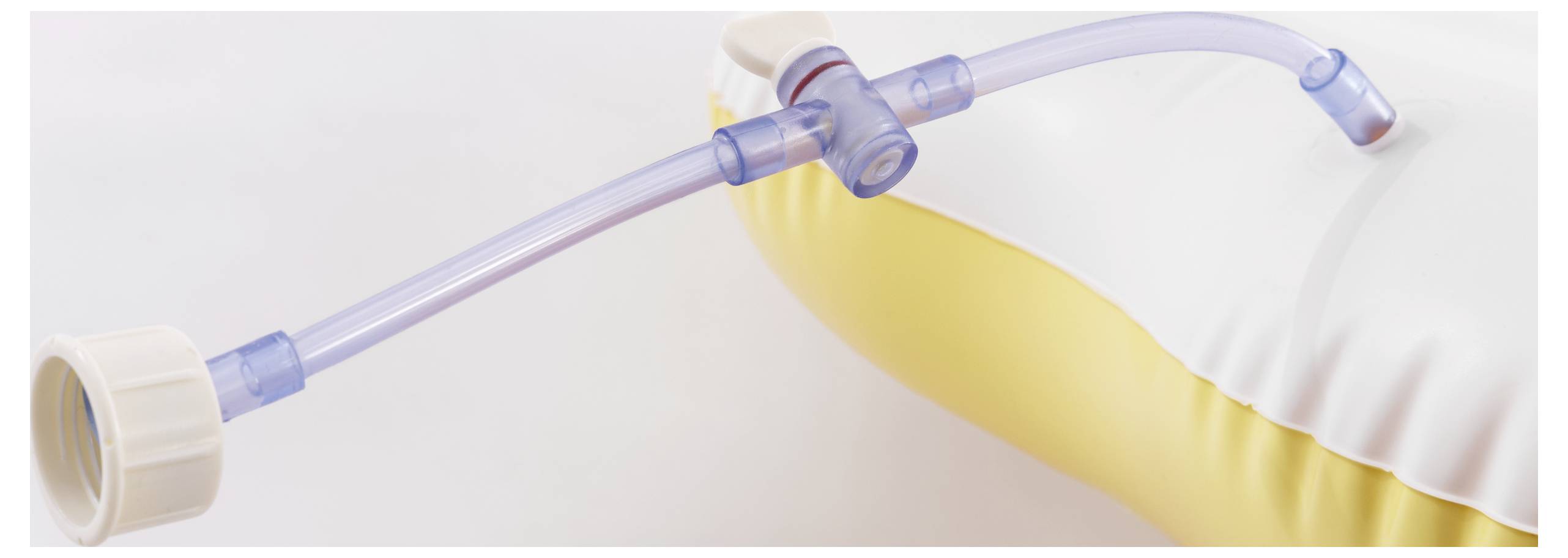 'Slangaansluiting bevestigd aan een opblaasbaar medisch kussen, met onderdelen voor luchtinblazing en luchtafblazing weergegeven.'