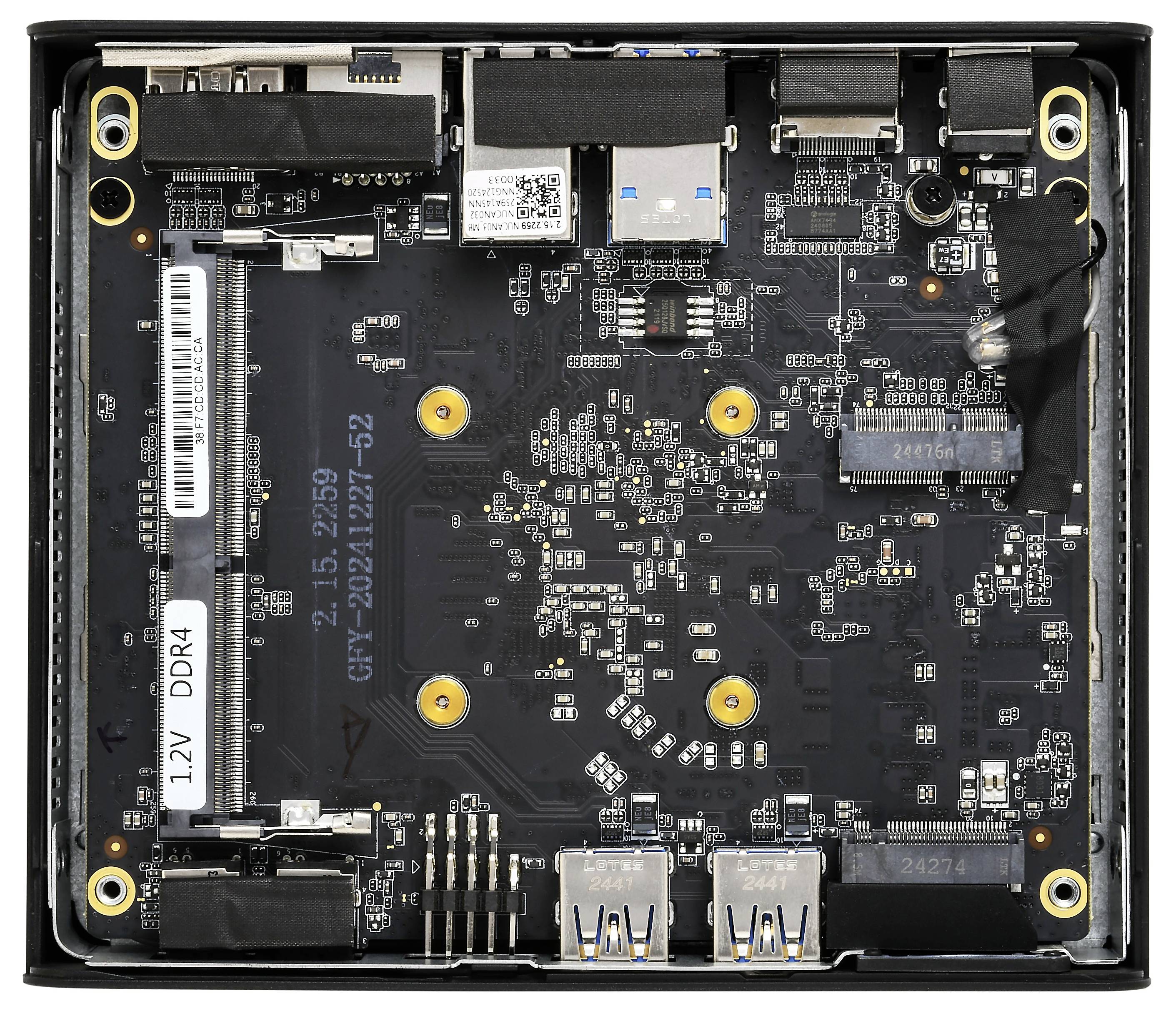 Een compacte computermoederbord met USB-poorten, RAM-sleuven gelabeld '12V DDR4' en verschillende connectoren, geplaatst in een kleine, vierkante behuizing.