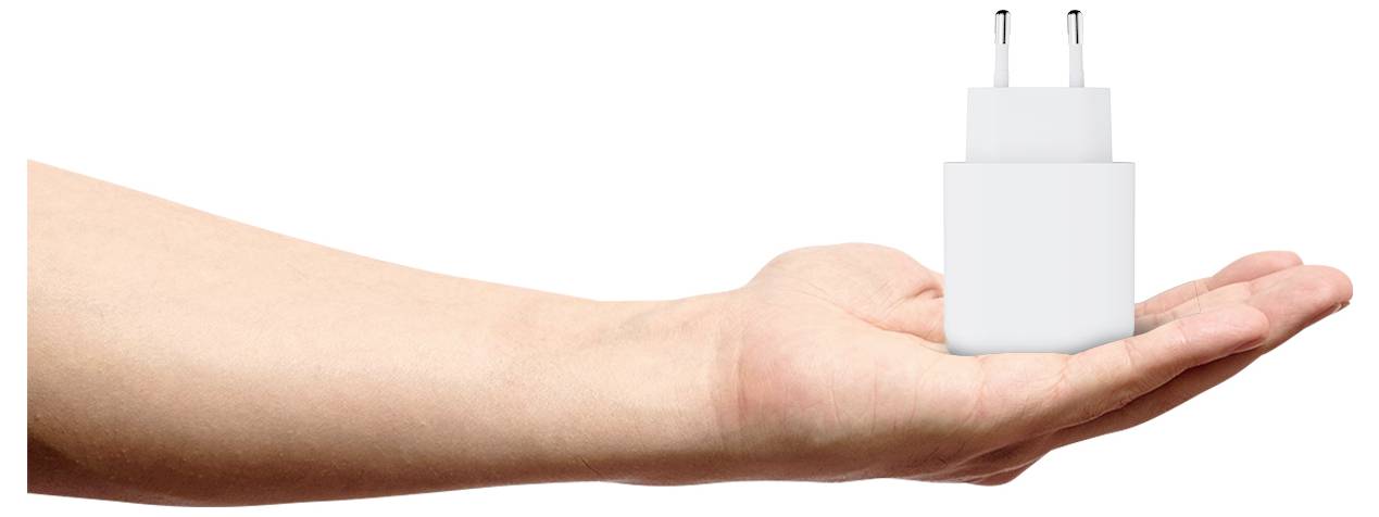 Een hand die een witte USB-wandlader met twee stekkers omhoog gericht vasthoudt.