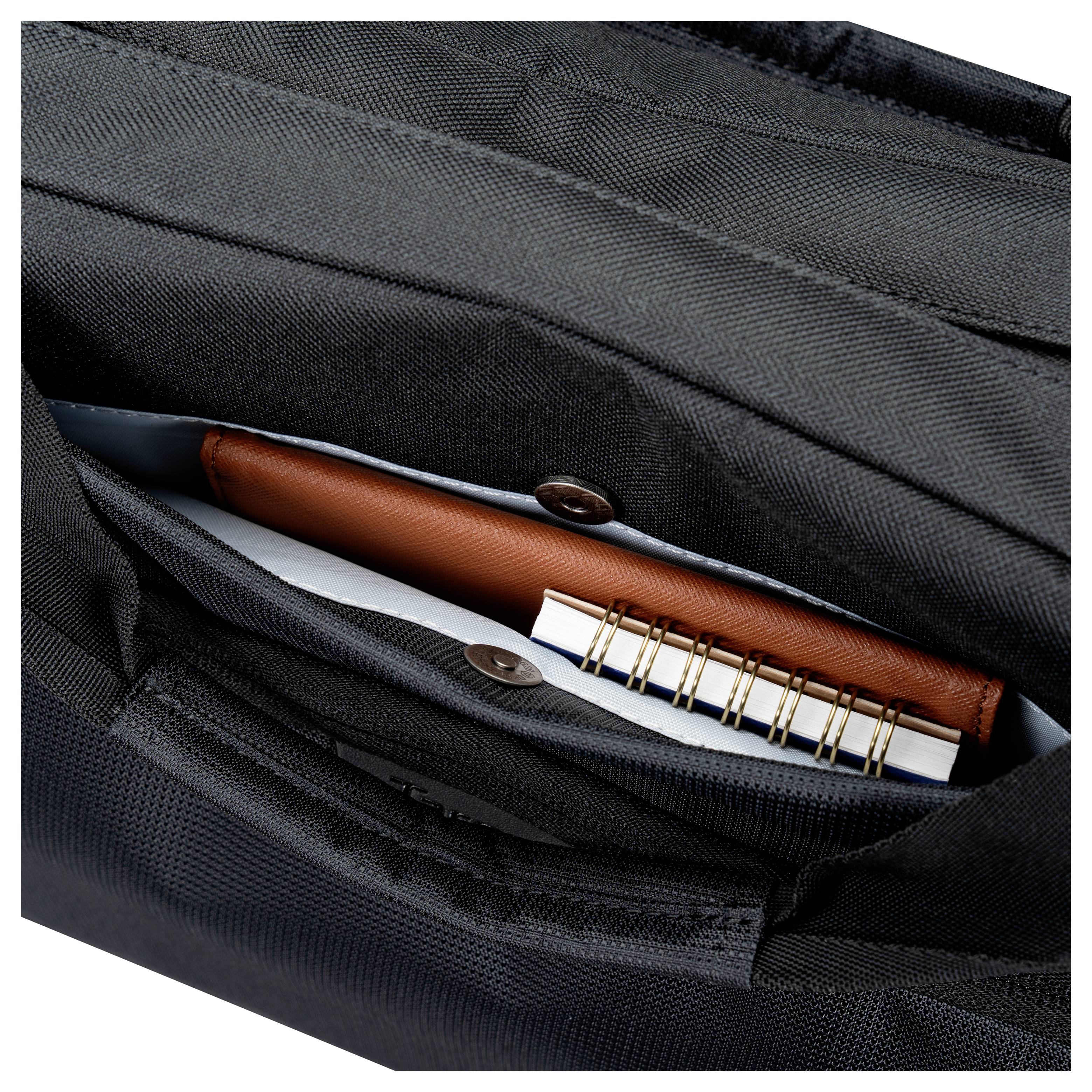 Open zwarte rugzak zak met een bruin notitieboekje, witte papieren en een pen.