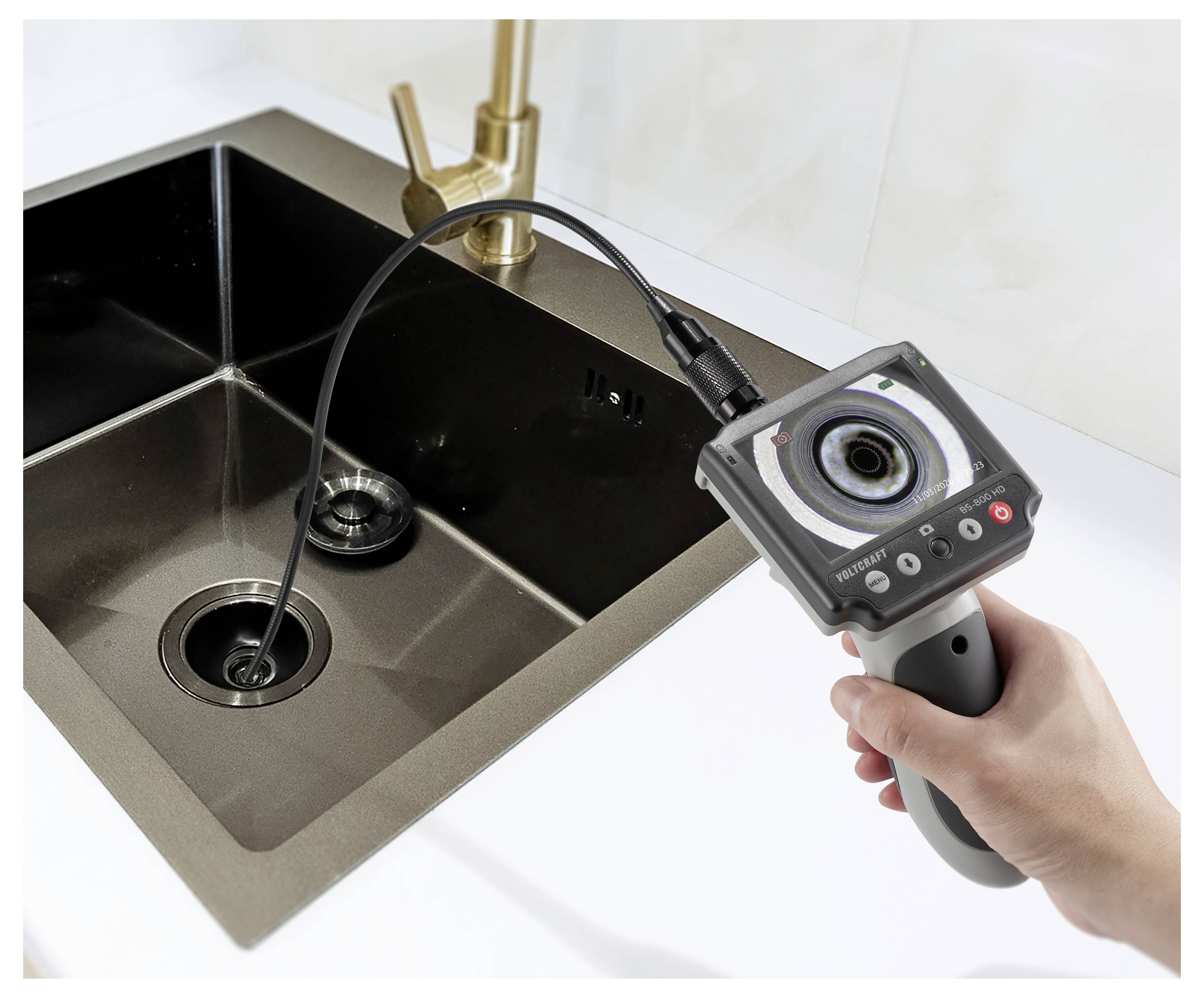 Handheld rioolcamera onderzoekt een keukenafvoer en afvoeropening van de voedselversplintering.