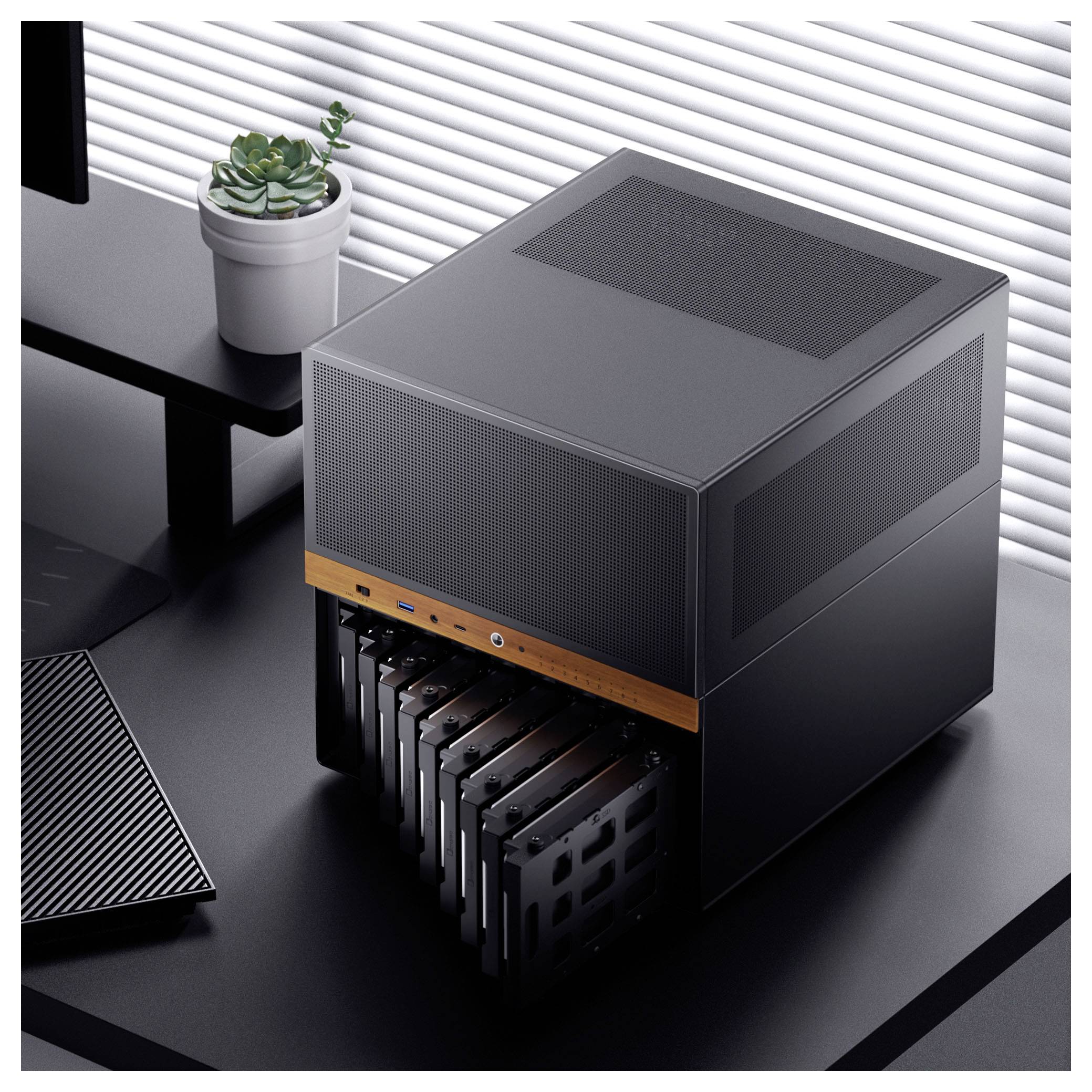 Een elegant zwarte computerserver met meerdere verwijderbare hardschijfsleuven op een modern bureau, naast een toetsenbord en een klein plantje.