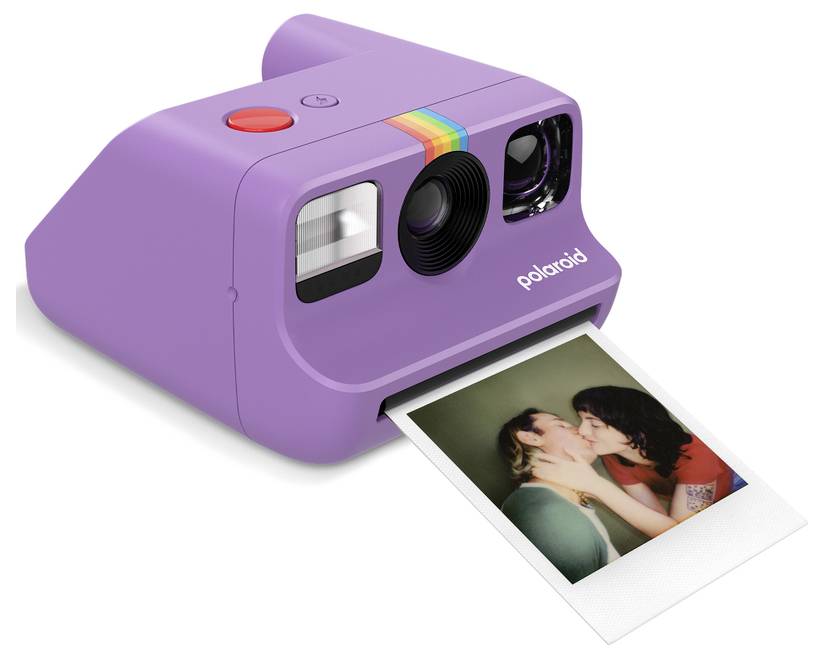 Een paarse Polaroid-camera naast zijn gekleurde doos, waarbij de voorkant van de camera met lens en flits zichtbaar is. De doos toont het ontwerp met regenboogstrepen.