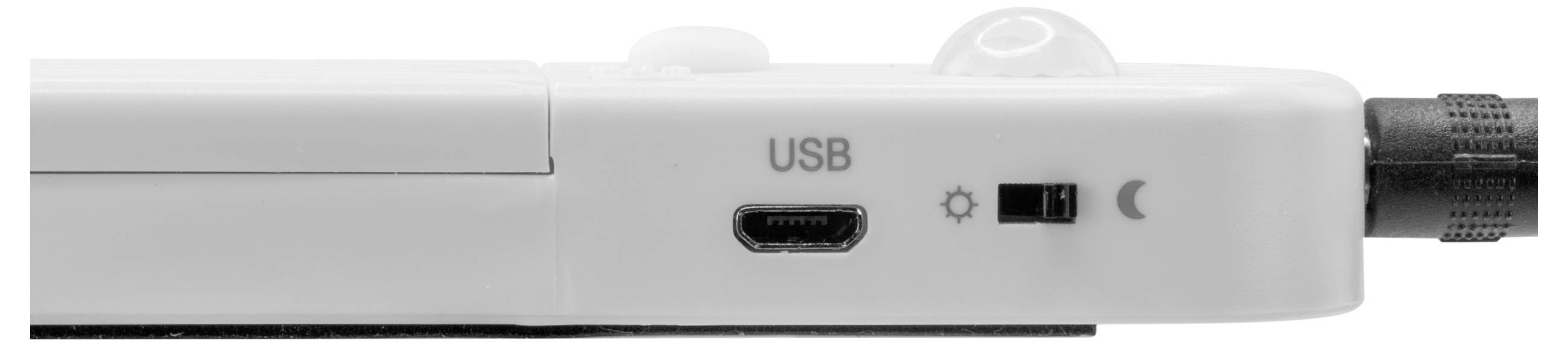 Close-up van een wit apparaatpaneel aan de zijkant met een USB-poort, een kleine schakelaar naast zon- en maanpictogrammen, en een aangesloten kabel aan de rechterkant.