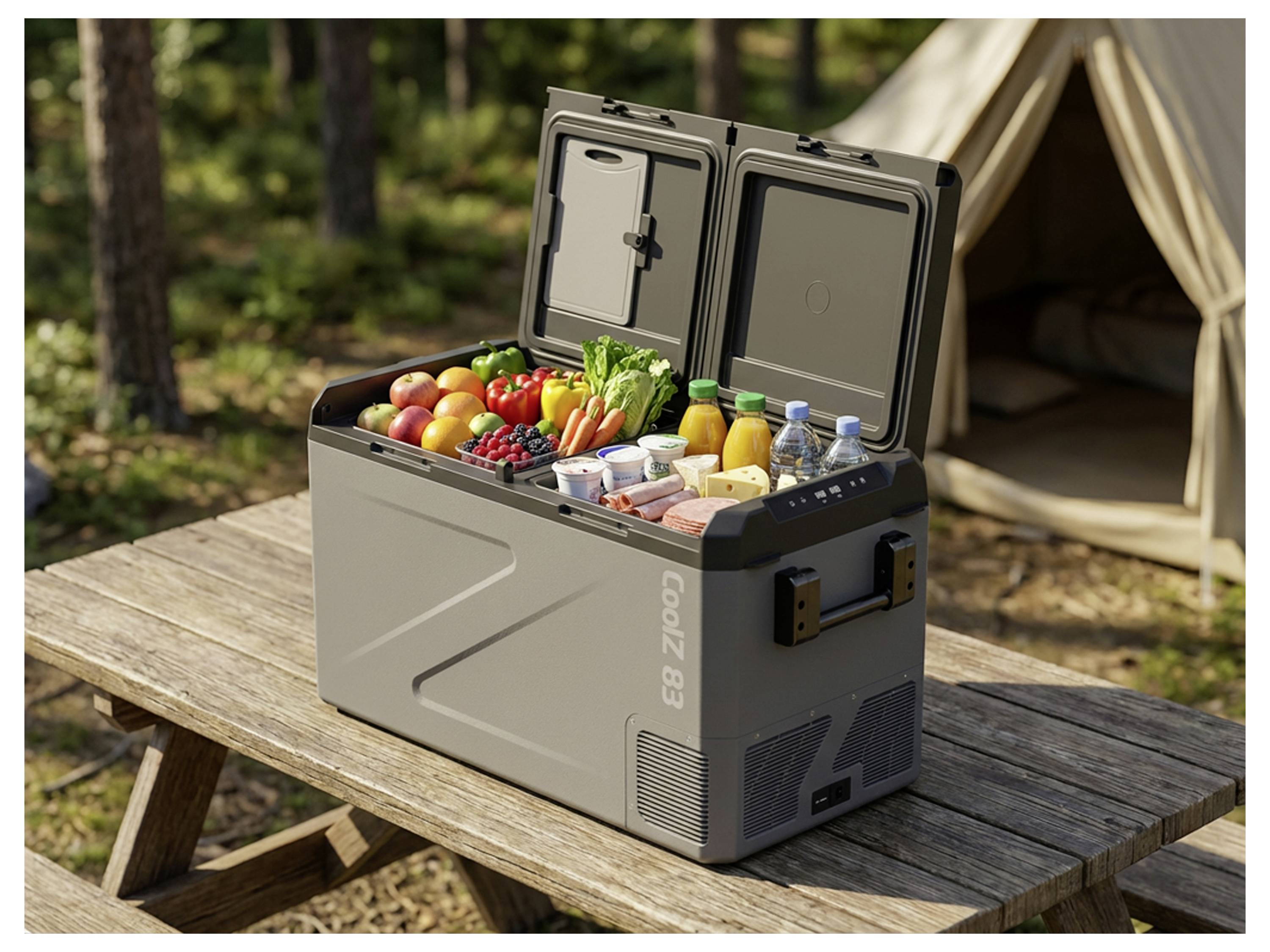 Draagbare koelbox gevuld met vers voedsel en dranken op een picknicktafel naast een tent op een campingplek.