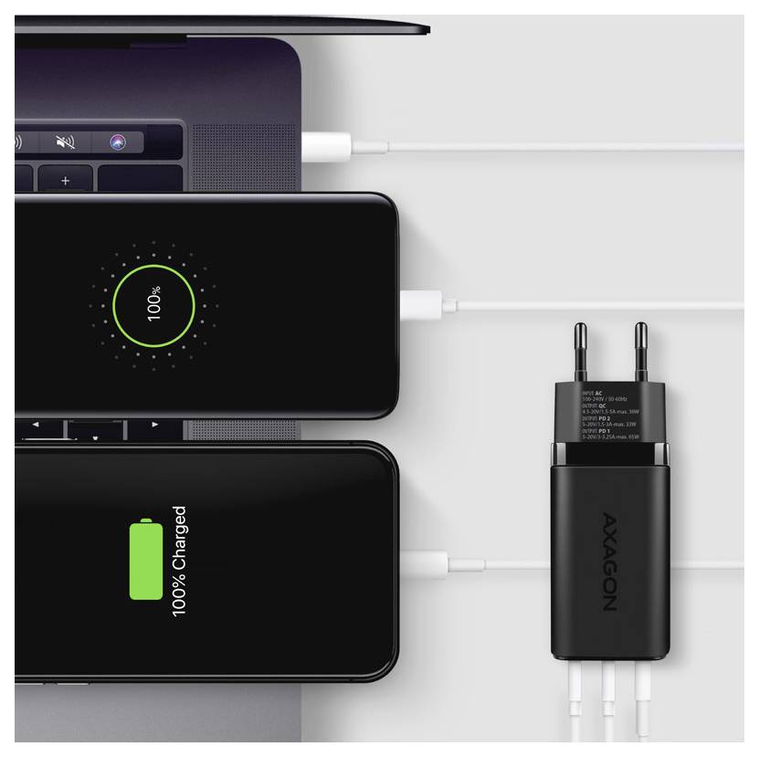 Drie smartphones laden op van een wandlader met meerdere poorten; een toont 100% en een ander '100% Charged' in een batterijpictogram.