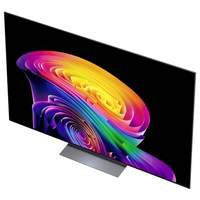 Een slanke flatscreen-tv die een levendige multicolor abstract wervelend patroon op een zwarte achtergrond weergeeft, schuin op een standaard geplaatst.