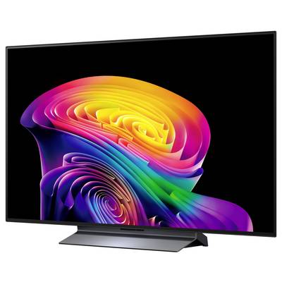 Een flatscreen-tv toont een levendige abstracte regenboogwerveling op een zwarte achtergrond, weergegeven in een driekwart weergave op een standaard.