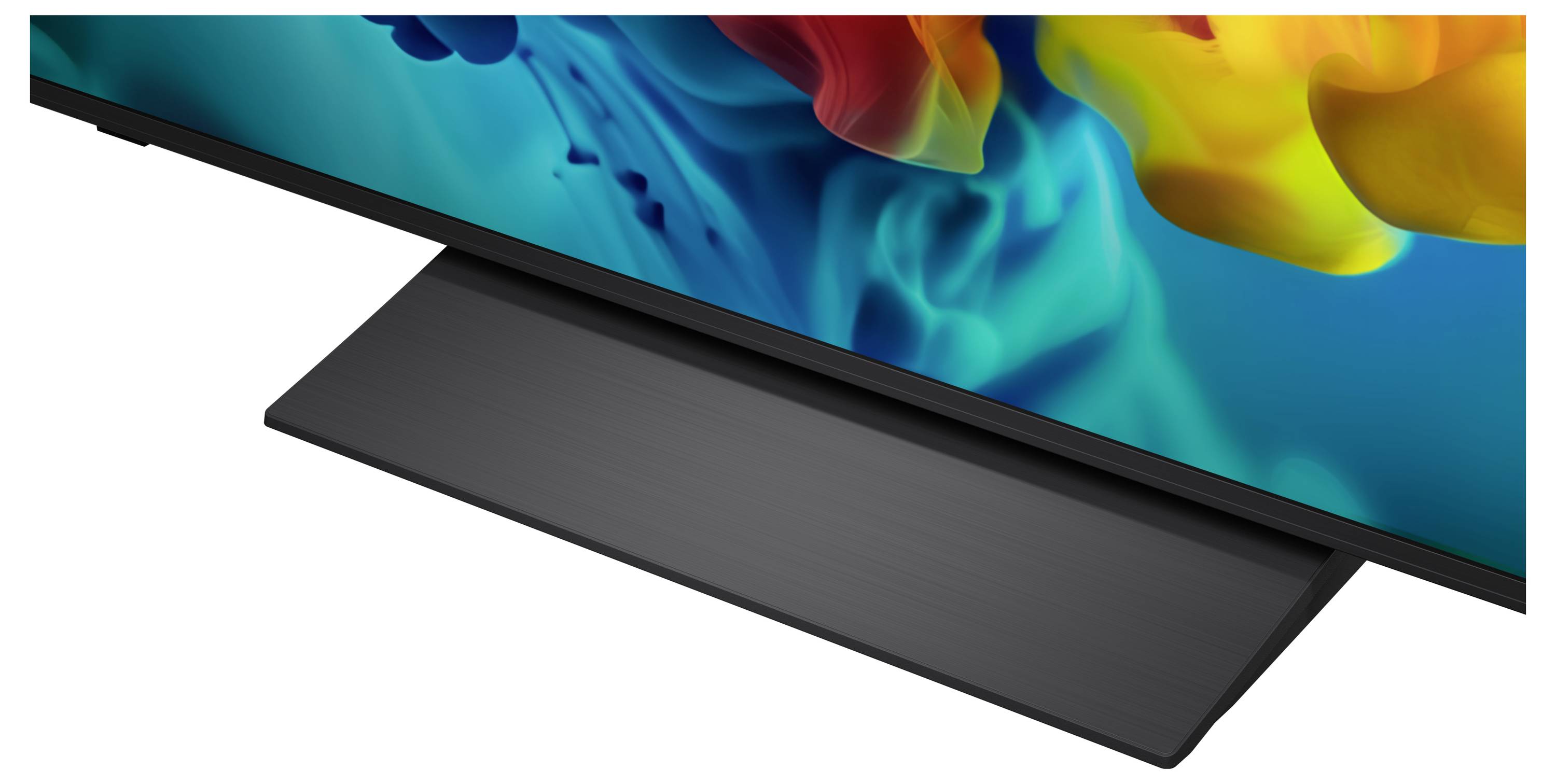 Close-up van een flatscreen-tv met een donkere driehoekige standaard op een witte achtergrond.