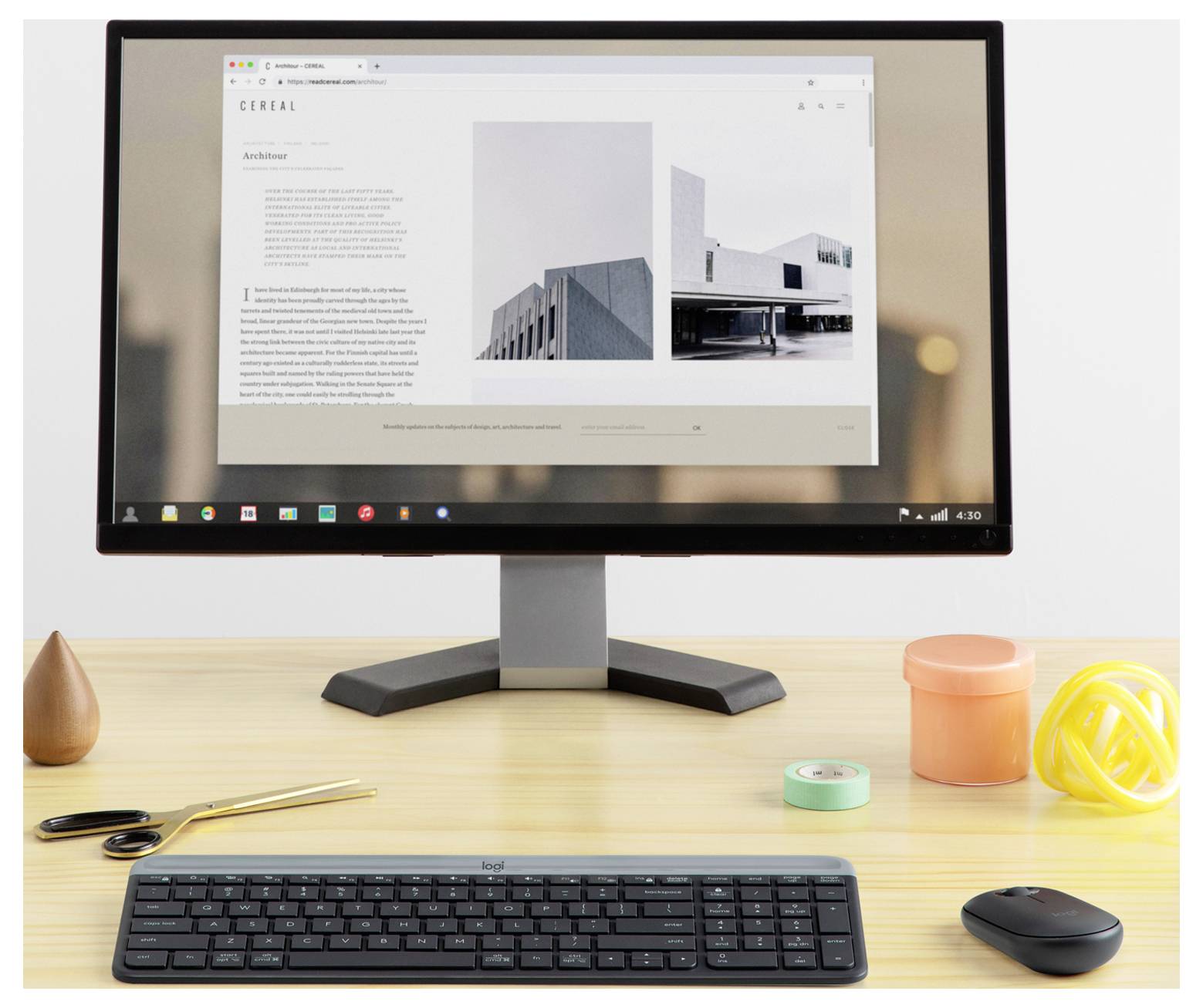 Desktopmonitor die een website met schone architectuur weergeeft op een bureau met toetsenbord en muis, in een minimalistische werkplek.
