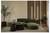 Modern woonkamer met groene hoeksectionale bank, ronde salontafels, potplanten en houten latenwand met verticale verlichting.