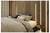 Netjes opgemaakt bed in een moderne slaapkamer met houten latten wand, neutraal beddengoed, kussens en een klein rond nachtkastje met decoratie.