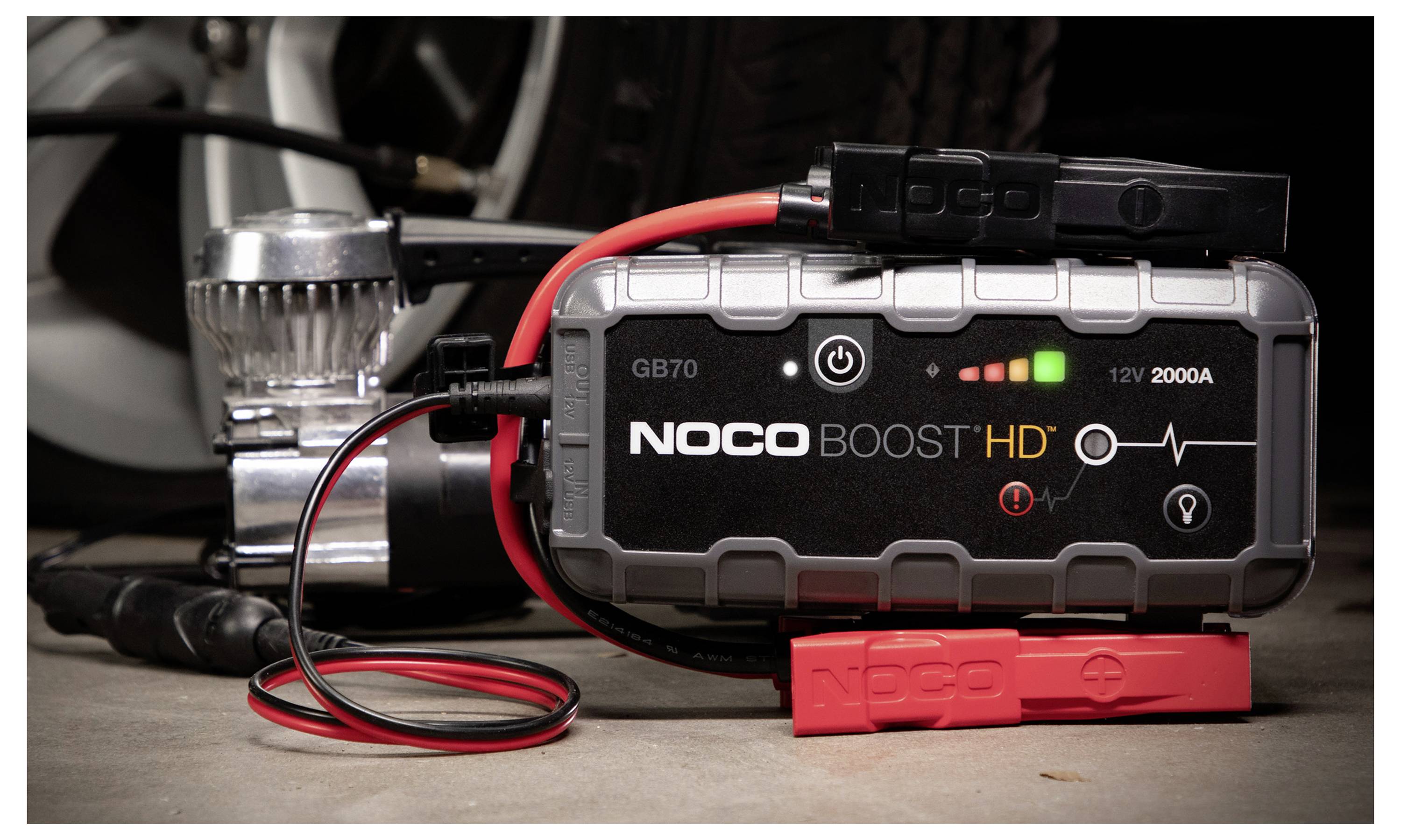 NOCO Boost HD draagbare autoaccu snelstarter met verbonden klemmen en kabels, met weergave van ladings- en 12V 2000A-indicatoren op het apparaatscherm.